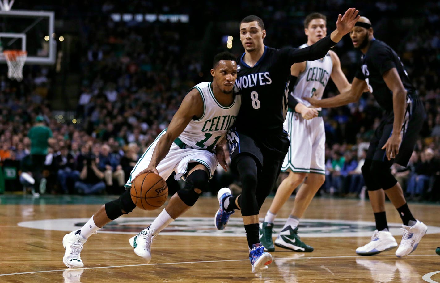 Boston Celtics guard Evan Turner (11) drives to the basket past Minnesota Timberwolves guard Zach LaVine (8) during the first quarter of an NBA basketball game in Boston, Monday, Dec. 21, 2015. (AP Photo/Charles Krupa)