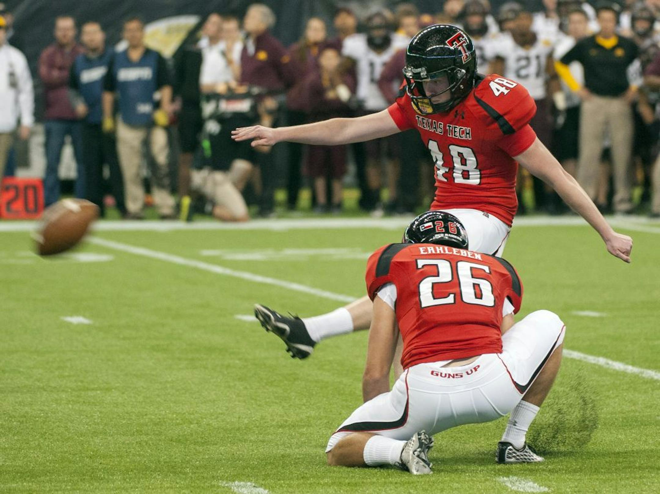 Texas Tech's Ryan Bustin (48) kicks a field goal to win the game as Ryan Erxleben (26) holds during the fourth quarter of the Meineke Car Care Bowl NCAA college football game against Minnesota, Friday, Dec. 28, 2012, in Houston. Texas Tech defeated Minnesota 34-31.