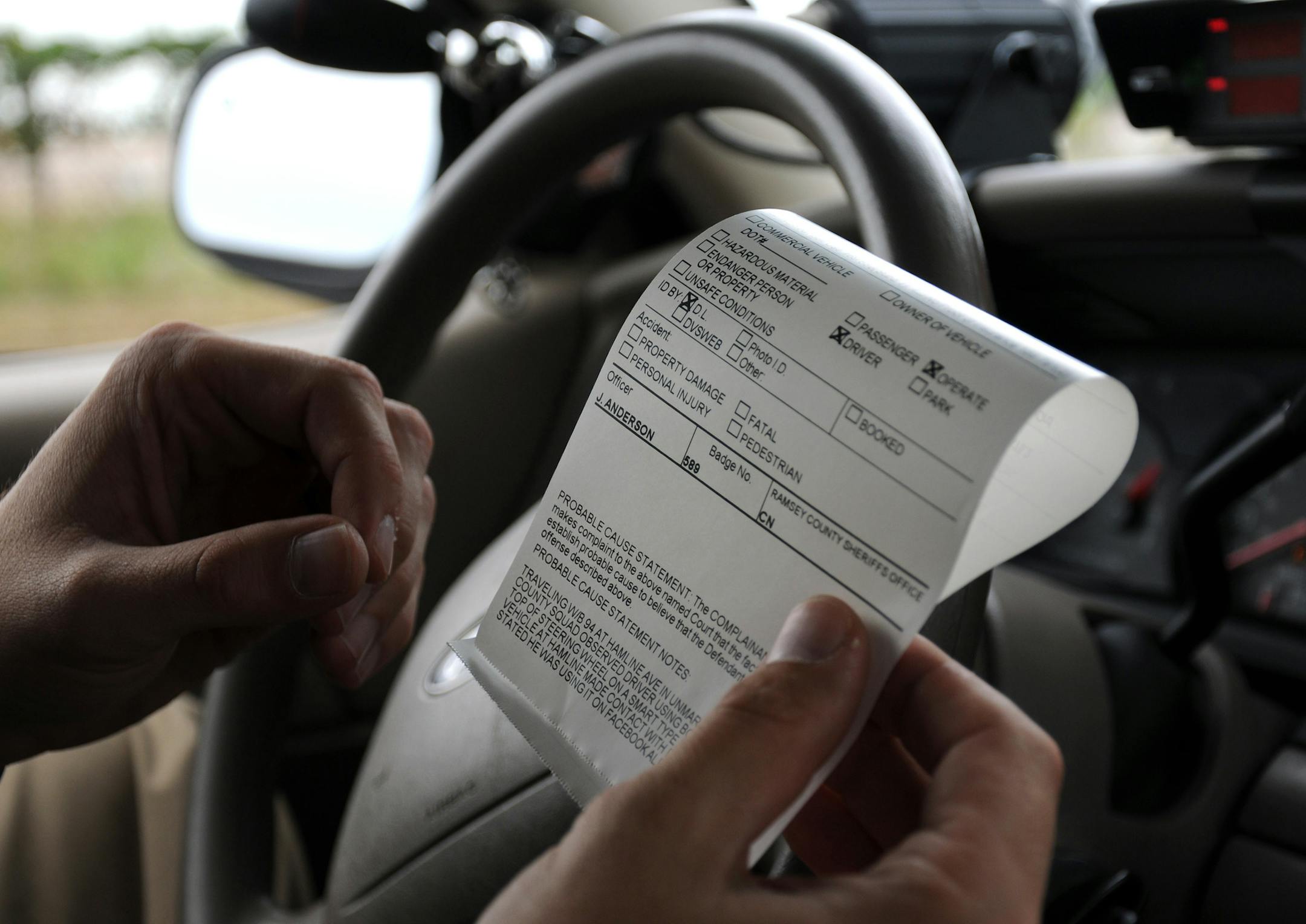 Richard Sennott•rsennott@startribune.com] St Paul, Mn. Friday 9/10/10 Ramsey County Sheriff deputy Jason Anderson wrote a citation report in his squad after citing a motorist for texting while driving on Interstate 94