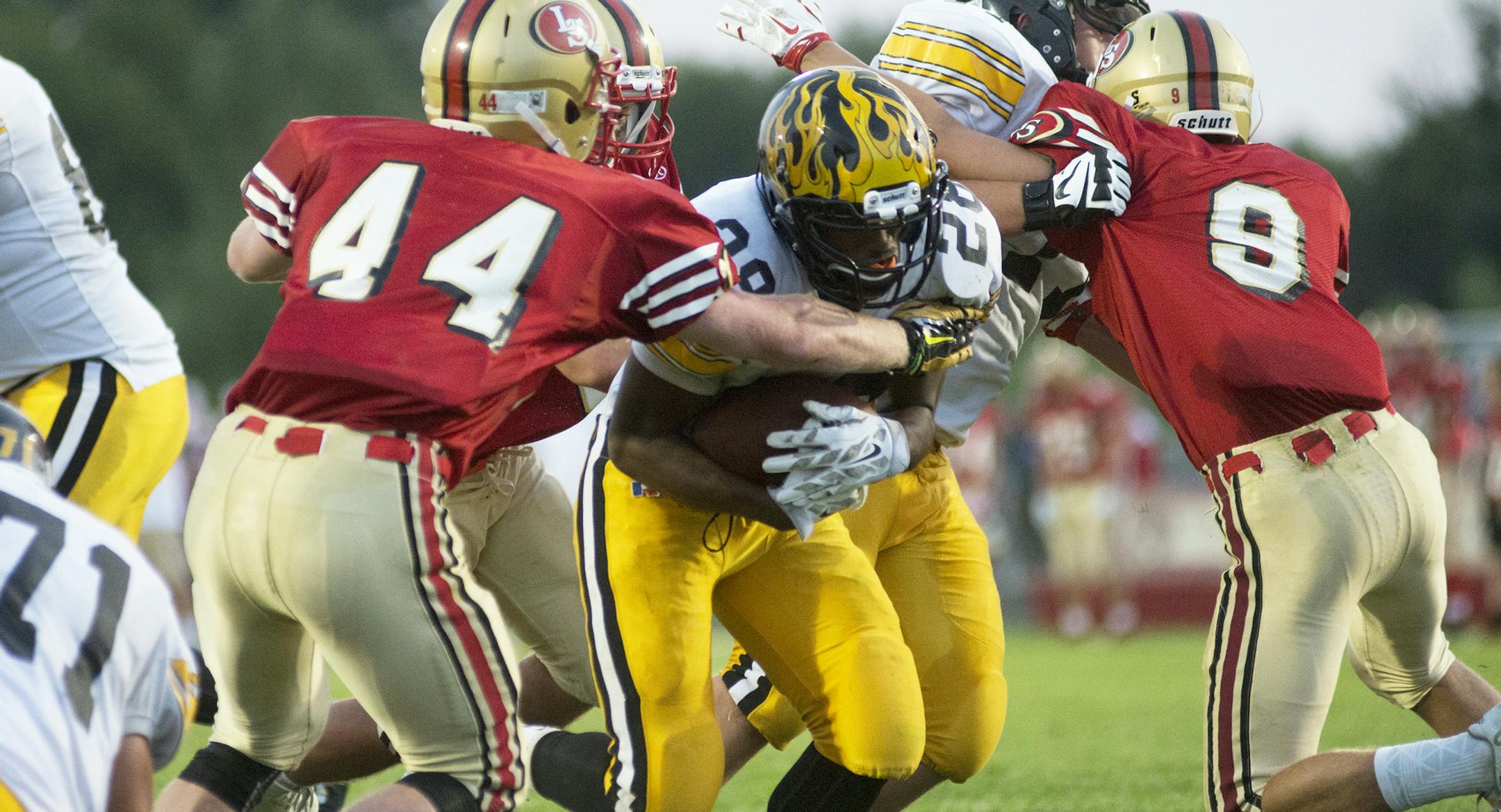 Burnsville's Stephan Olson Jr. protects the ball as he brings one in for a touchdown, Friday, August 28, during a game against Lakeville South at Lakeville South High School. (Matthew Hintz, 082815, Lakeville)