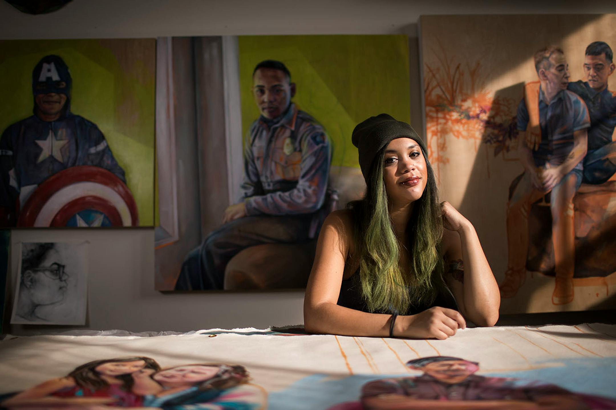 Artist Leslie Barlow poses for a photo in her studio with some of her paintings.
