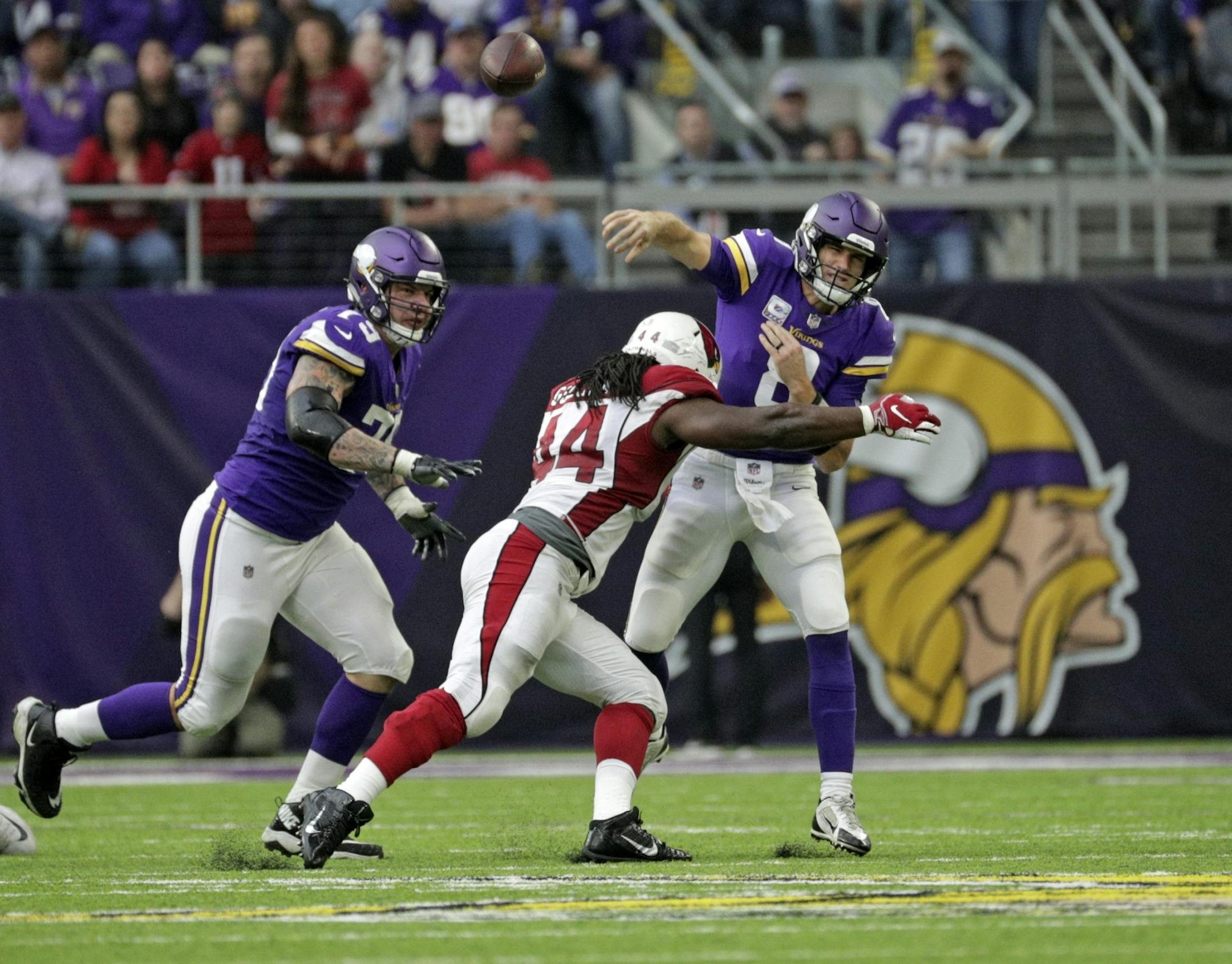 Vikings quarterback Kirk Cousins gets pressure late in the 2nd quarter by Arizona's Marcus Golden.