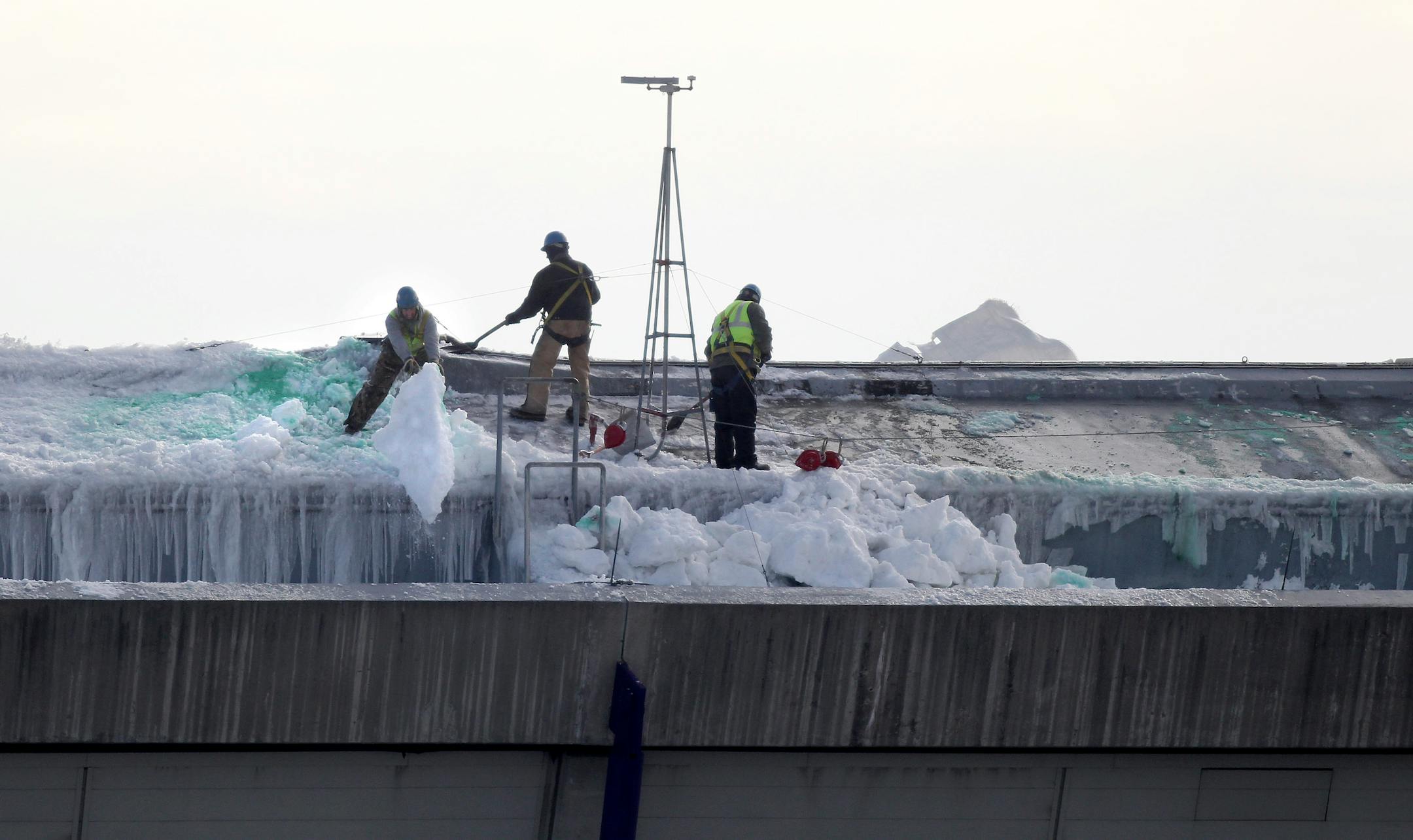 As pieces of the dome flew behind, a crew worked on shoveling snow from the dome early Tuesday morning.