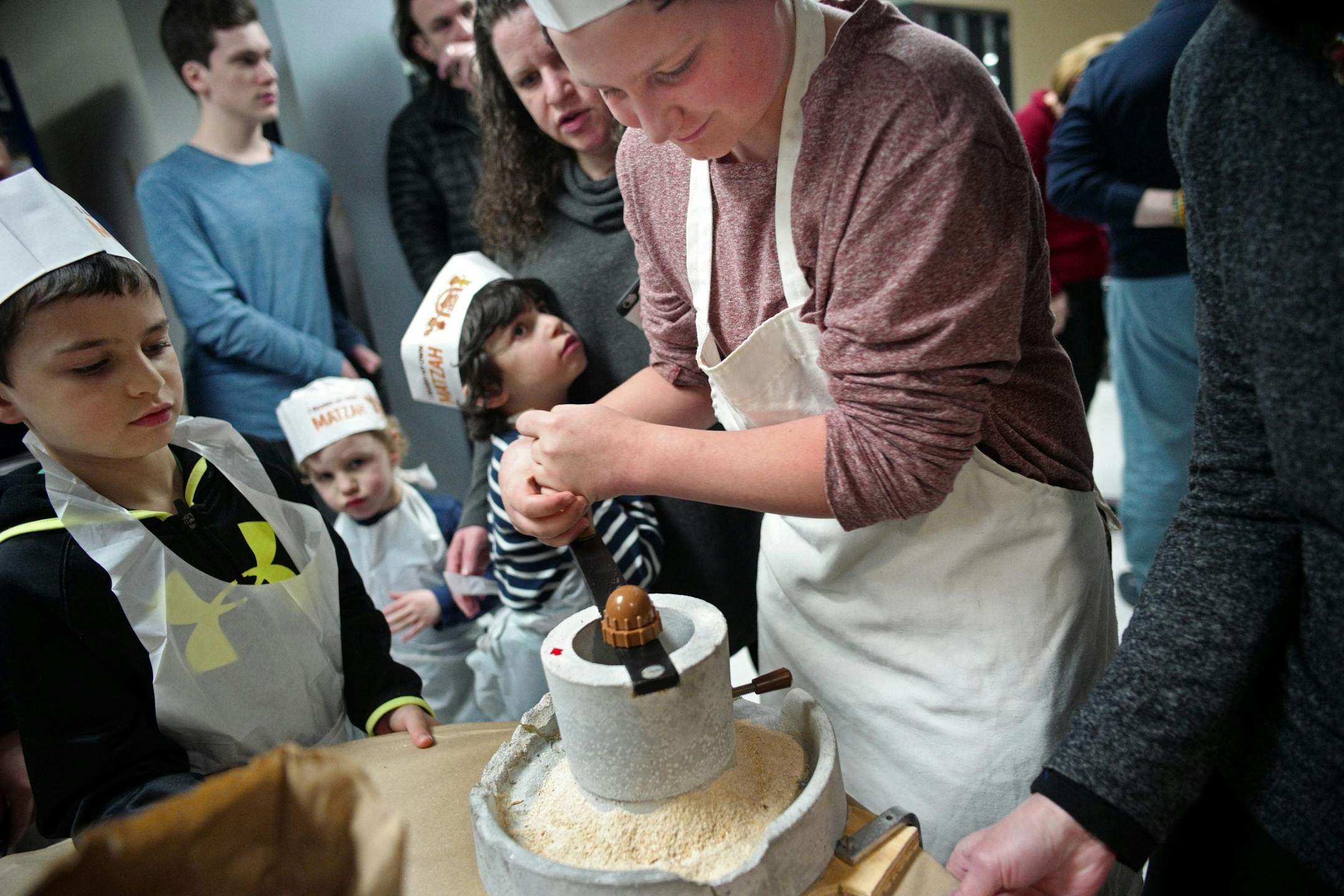 Gabe Kay ground the wheat into flour as Mark Makhlin,10, far left looked on.