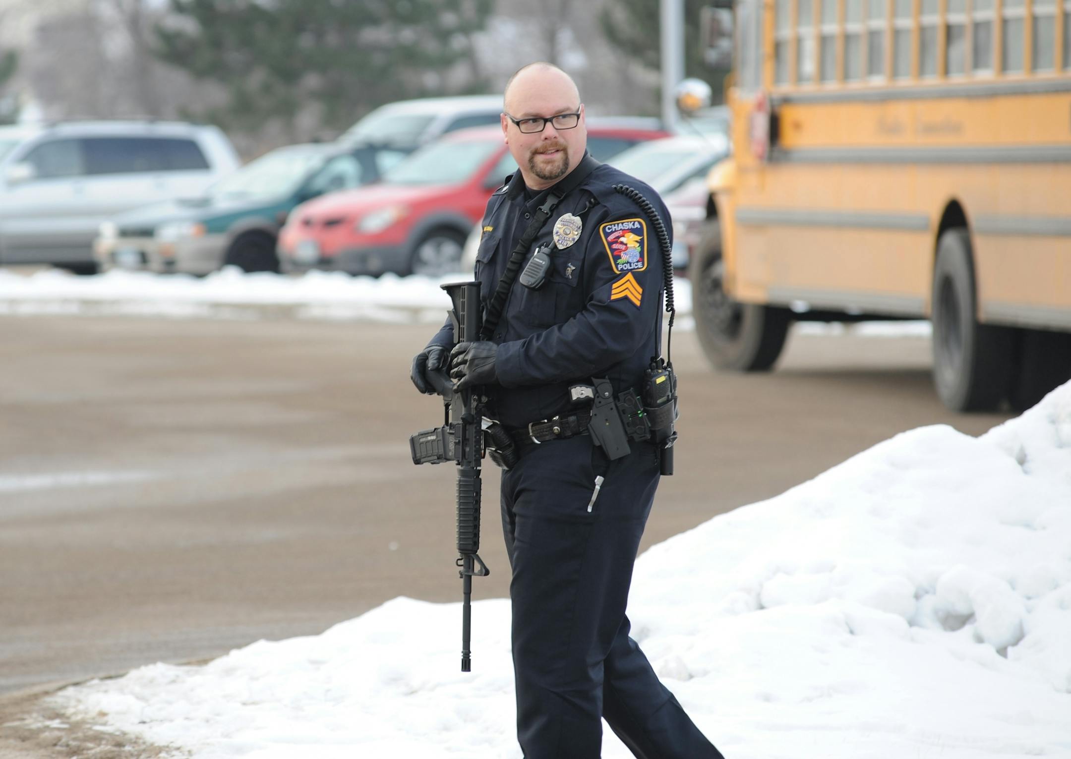 Chaska High School was in lockdown mode with police cars blocking all entrances. As the students were being released and the buses were leaving the school this Chaska police officer was monitoring the situation while carrying an assault rifle.