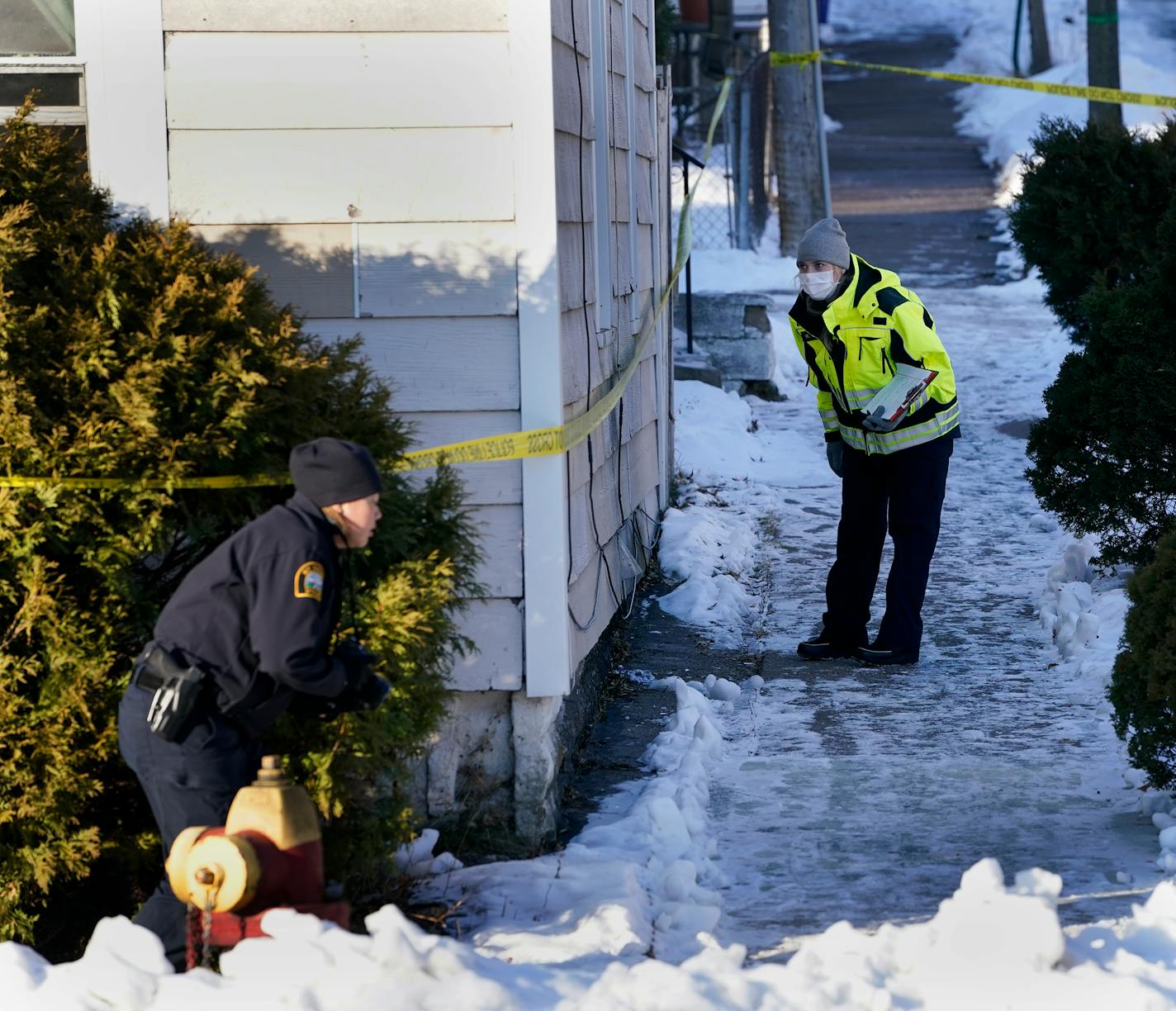 Law enforcement officers investigate the scene on Payne Ave. N. at North St. where a shooting left two people dead Thursday in St. Paul. ]