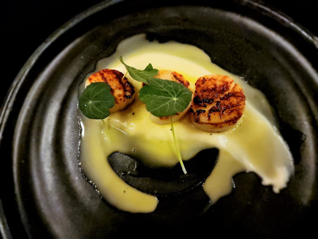 Grilled scallops over parsnip cream were part of a seven-course chef’s dinner at Tullibee