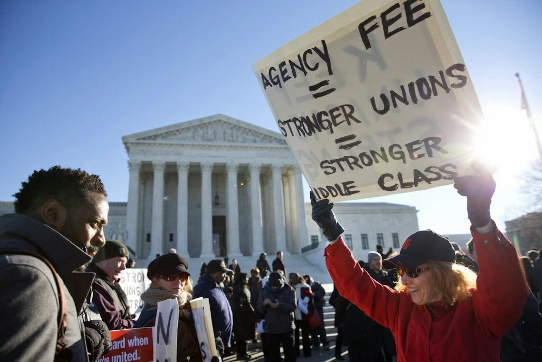 Lesa Curtis of Westchester, N.Y., right, who is pro agency fees and a former president of her union, rallies outside of the Supreme Court in Washington, Monday, Jan. 11, 2016, as the court heard arguments in the 'Friedrichs v. California Teachers Association' case. The justices were to hear arguments in a case that challenges the right of public-employee unions to collect fees from teachers, firefighters and other state and local government workers who choose not to become members.
