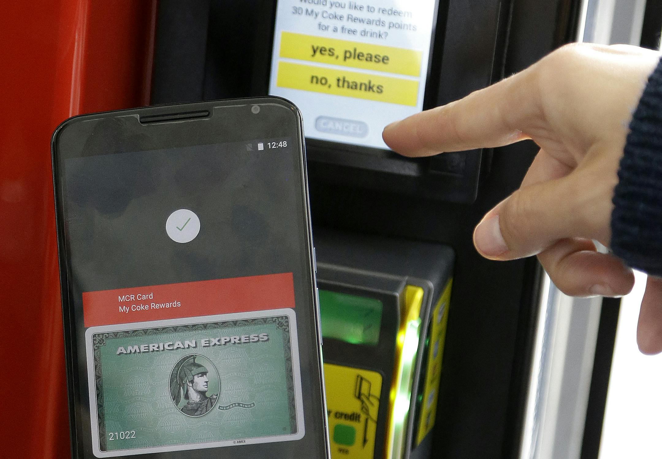 A Google employee gives a demonstration of Android Pay on a phone at Google I/O 2015 in San Francisco, Thursday, May 28, 2015. Google's next version of its Android operating system will boast new ways to fetch information, pay merchants and protect privacy on mobile devices as the Internet company duels with Apple in the quest to make their technology indispensable. (AP Photo/Jeff Chiu)