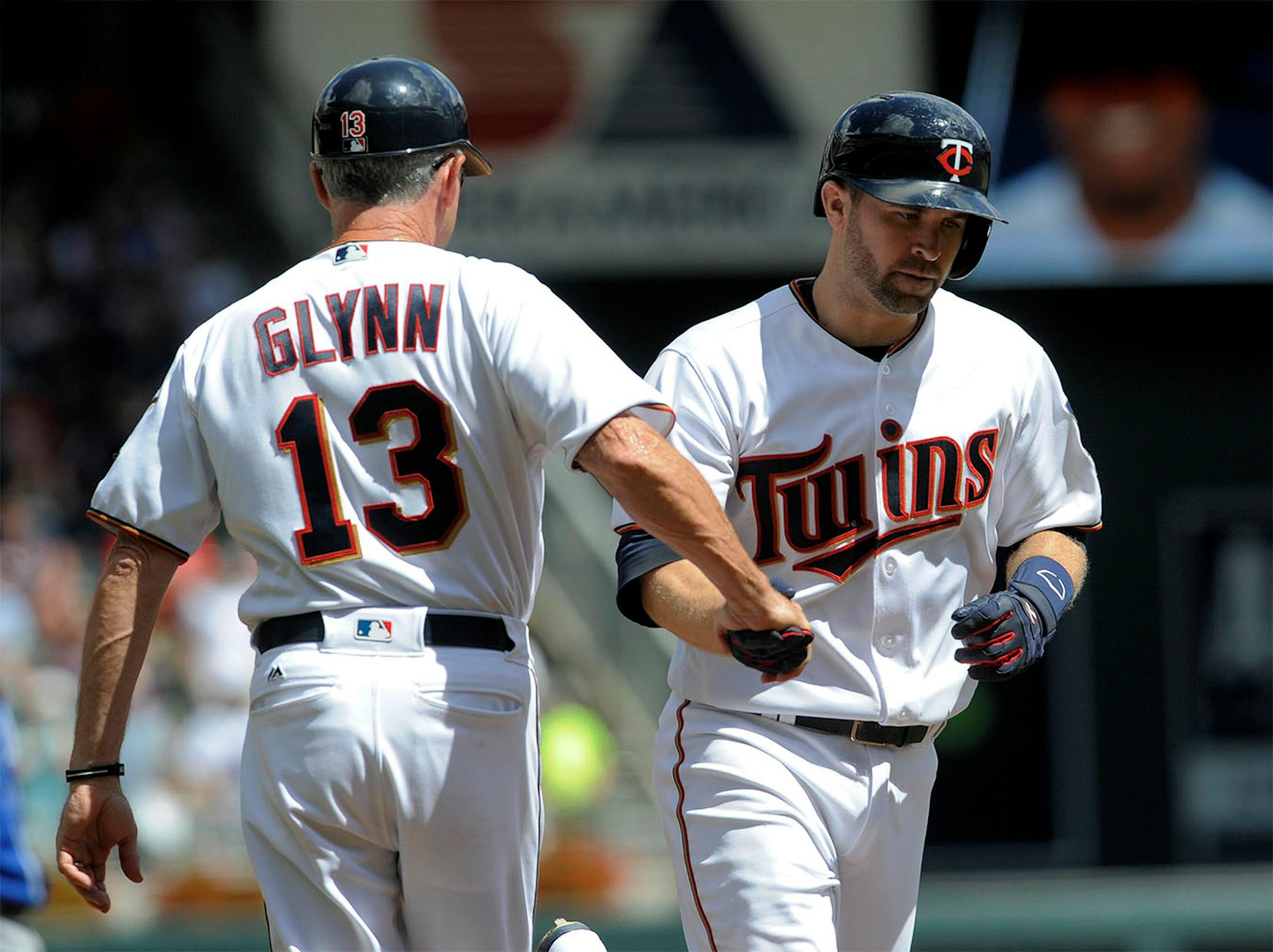 Minnesota Twins' Brian Dozier, right, is congratulated by third base coach Gene Glynn (13) after hitting a solo home run off Kansas City Royals pitcher Mike Minor in the third inning of a baseball game, Sunday, Aug. 14, 2016, in Minneapoiis.