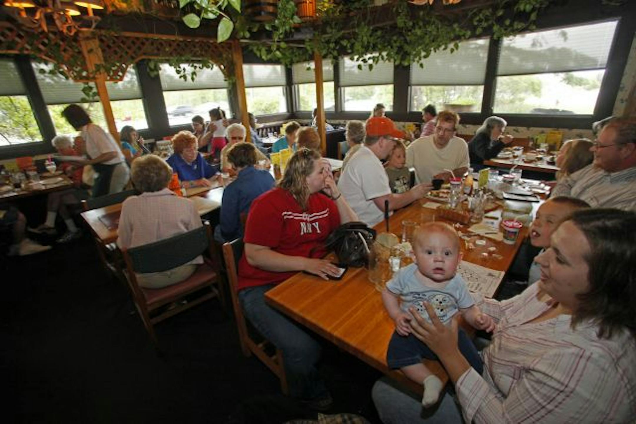 Diners packed the dining room on the last day of service. Foreground is Austin Hanson, 6 months, and mother Sarah Hanson, both of Isanti.