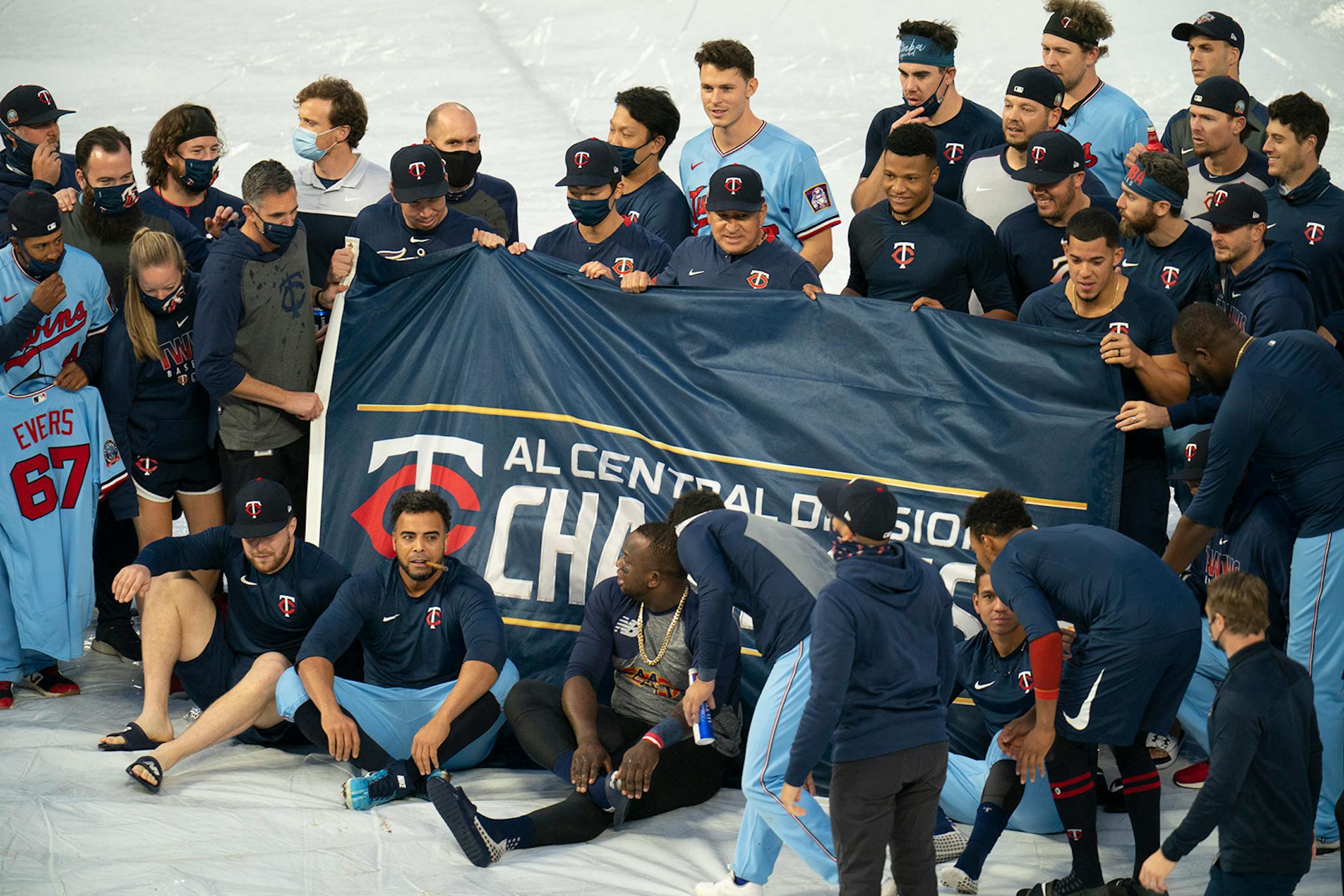 Twins players gathered on the field for a team photo with a championship banner.