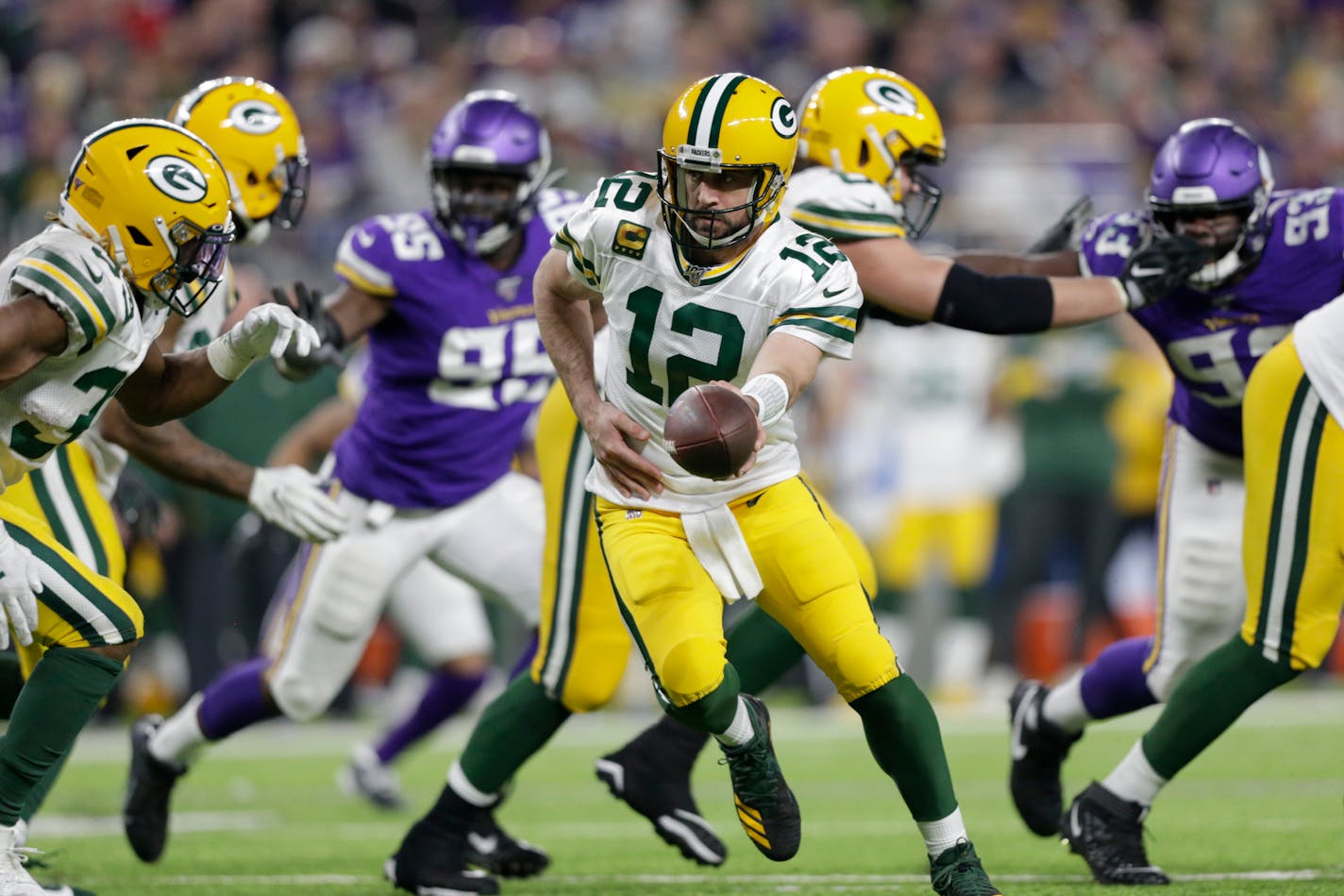 Packers quarterback Aaron Rodgers hands the ball off during the second half vs. the Vikings last season.