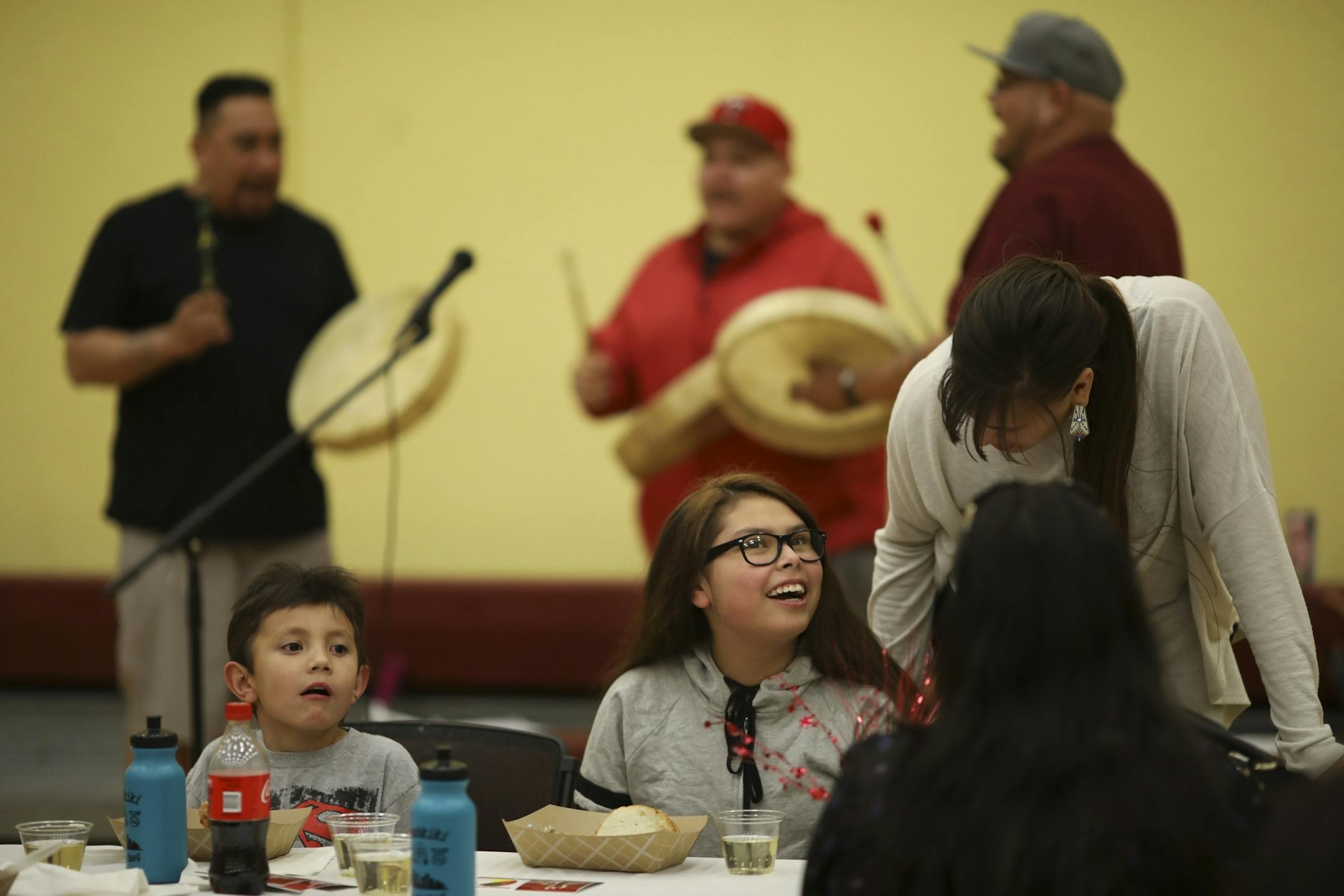 Hailey Yellow's former teacher, Kassie Benjamin, standing, stopped by her table to say hello as they ate dinner. At left was Hailey's brother, Julien Murphy, who won an attendance award.
