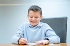 Caden Baune, 9, winner of the 2024 Zaner-Bloser national handwriting competition for fourth-graders, competes in a handwriting contest against journal