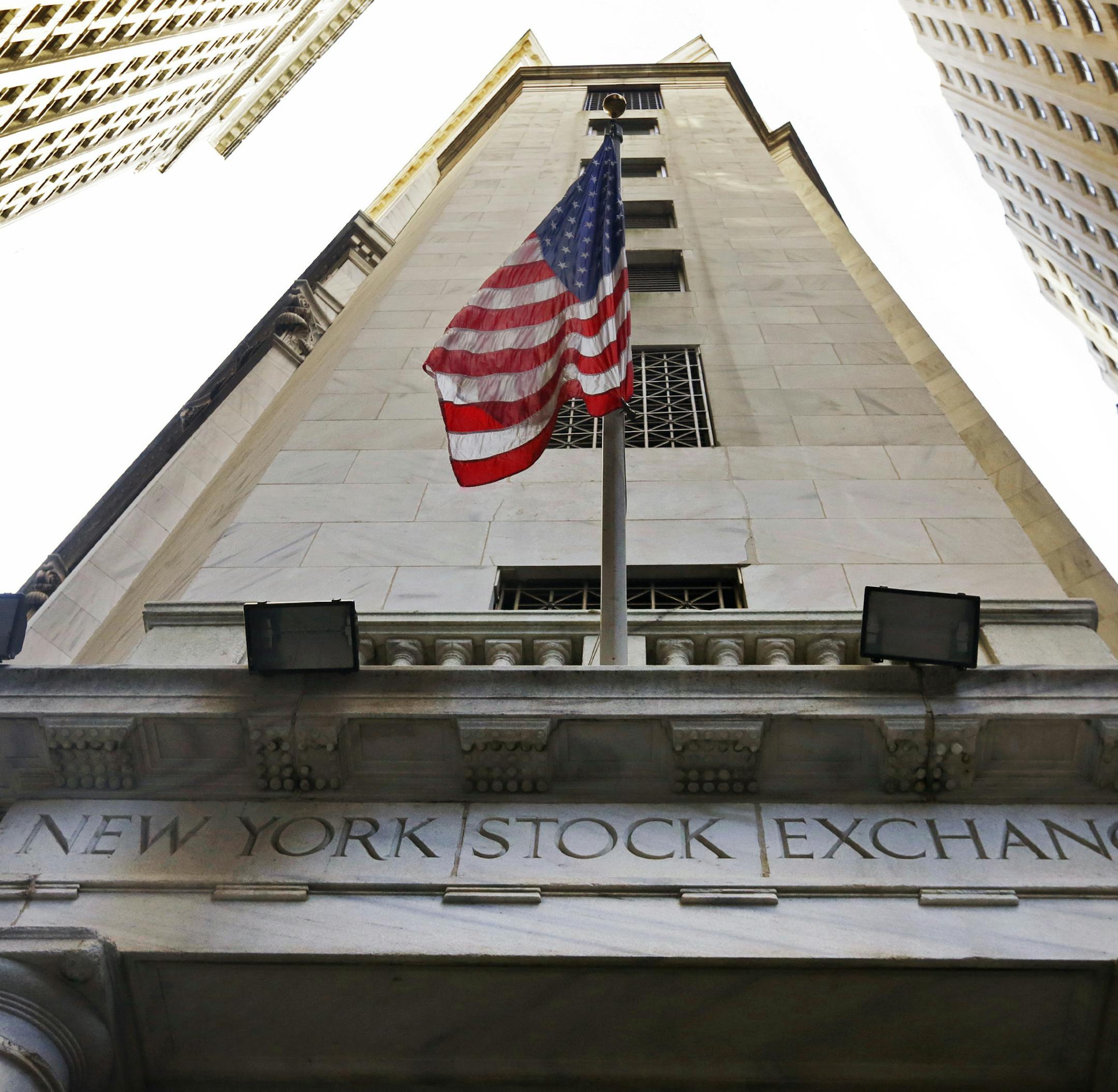 FILE - In this Friday, Nov. 13, 2015, file photo, the American flag flies above the Wall Street entrance to the New York Stock Exchange. Global stock markets traded in fairly narrow ranges Tuesday, Sept. 19, 2017, as investors paused for breath, a day after U.S. stock markets struck a record high and geared up for the latest interest rate decision from the U.S. Federal Reserve. (AP Photo/Richard Drew, File)