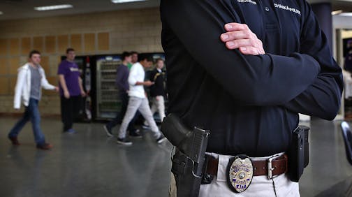 School resource officer Trent Wurtz carries a Glock 357 handgun on his side along with his Chaska Police Department badge as he periodically monitors the hallways and lunch area at Chaska High School.