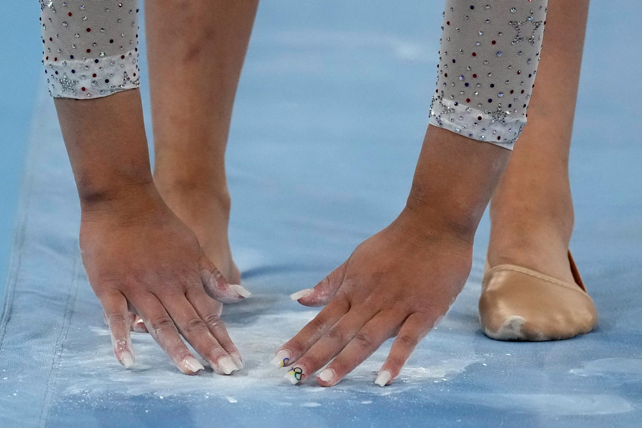 Suni Lee, of the United States, powders her hands before her performance on the balance beam during the artistic gymnastics women's all-around final at the 2020 Summer Olympics, Thursday, July 29, 2021, in Tokyo. (AP Photo/Ashley Landis)
