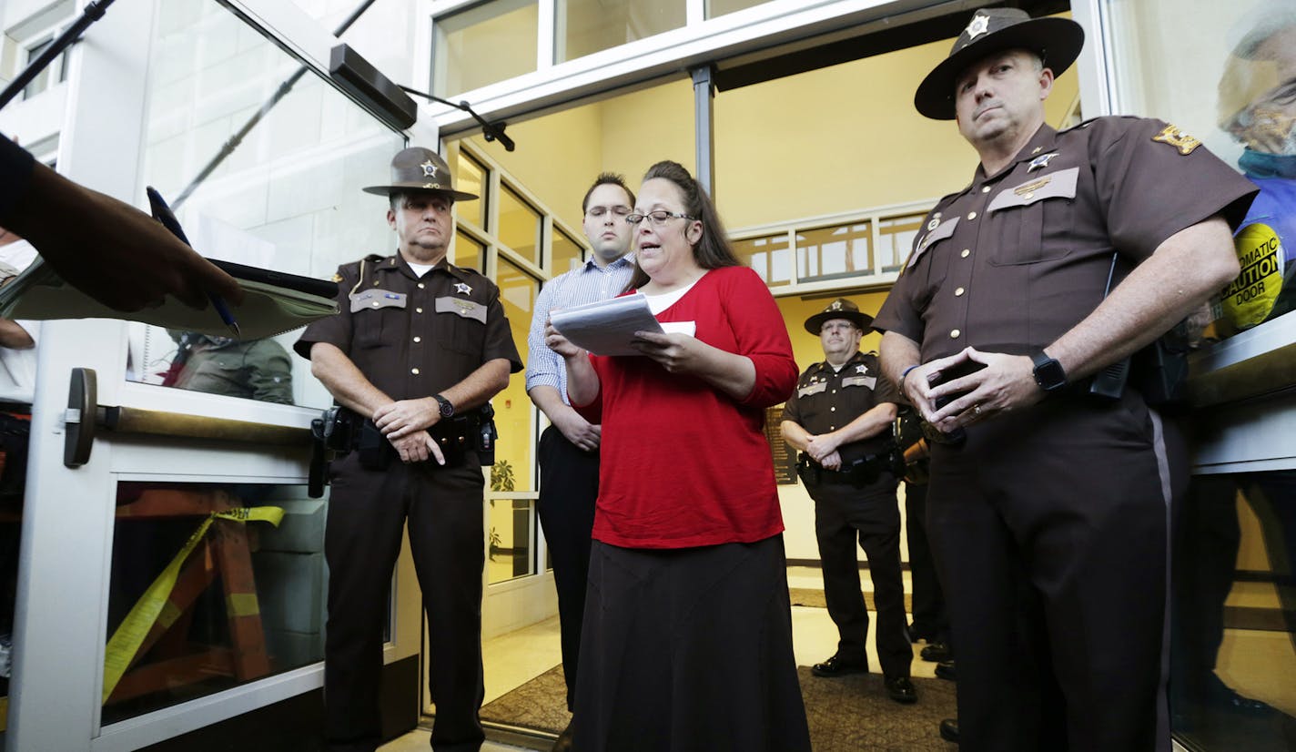 Rowan County Clerk Kim Davis, with son Nathan Davis, a deputy clerk, reads a statement to the press outside the Rowan County Courthouse on Sept. 14, 2015 in Morehead, Ky.