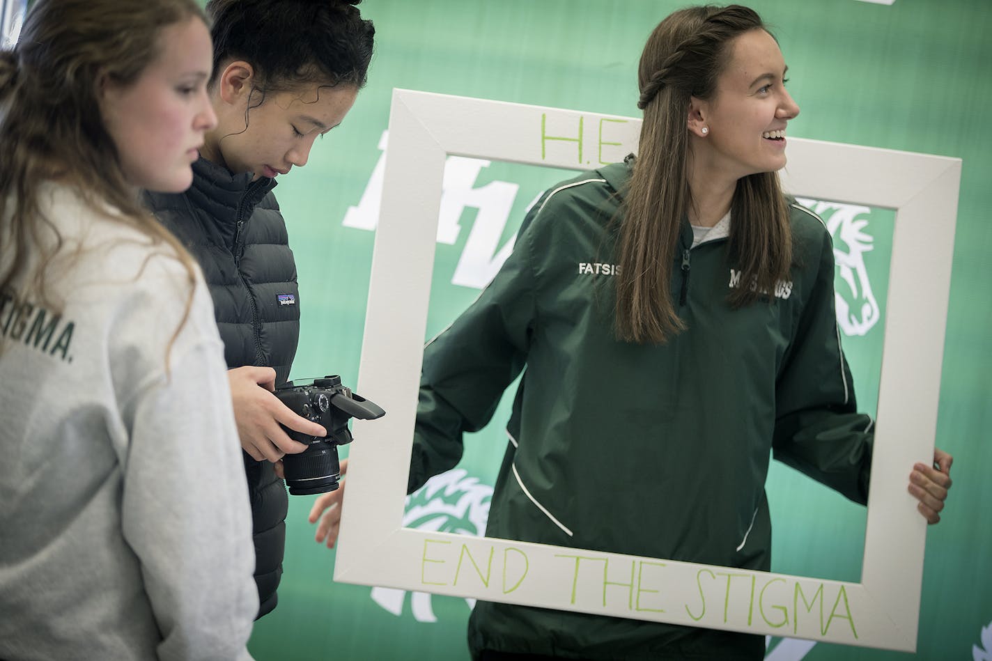 Mounds View High student Echo Fatsis, right, participated in the H.E.A.R.T - Helping Every At-Risk Teen - wellness week by posing in a makeshift photo booth after answering the question: "how do you practice wellness," in the school's cafeteria, Friday, April 27, 2018 in Arden Hills, MN.