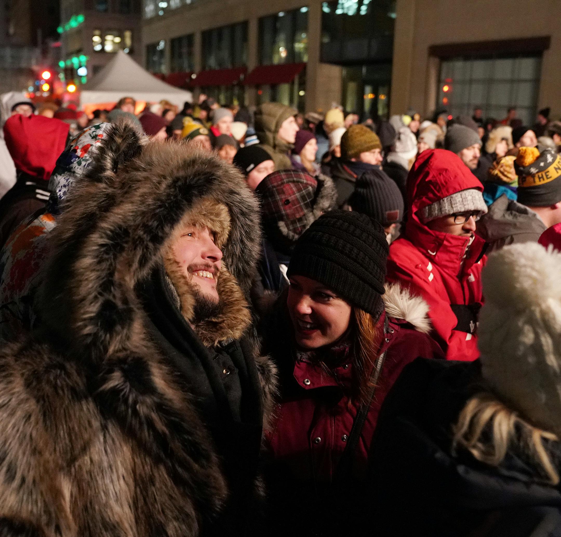 Michael Eldon, left, of Plymouth kept warm in a huge faux fur coat as he and his friend Inna Guminskiy of St. Louis Park waited for Matt and Kim to perform on Nicollet Mall Friday night. ] ANTHONY SOUFFLE • anthony.souffle@startribune.com The Great Northern is hosting a free outdoor concert with Brooklyn-based indie pop duo Matt and Kim just days after the polar vortex Friday, Feb. 1, 2019 on Nicollet Mall in downtown Minneapolis. The Great Northern presented by Target is an annual 10-day