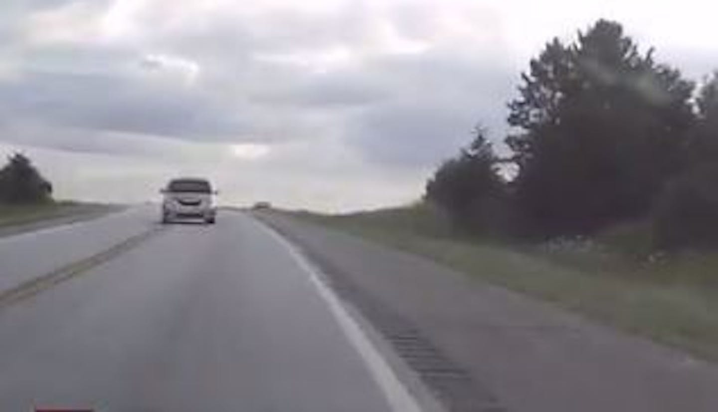 This image from a dashcam video shows a Minnesota driver swerving onto the shoulder to avoid a head-on crash with a distracted driver who crossed the center line.