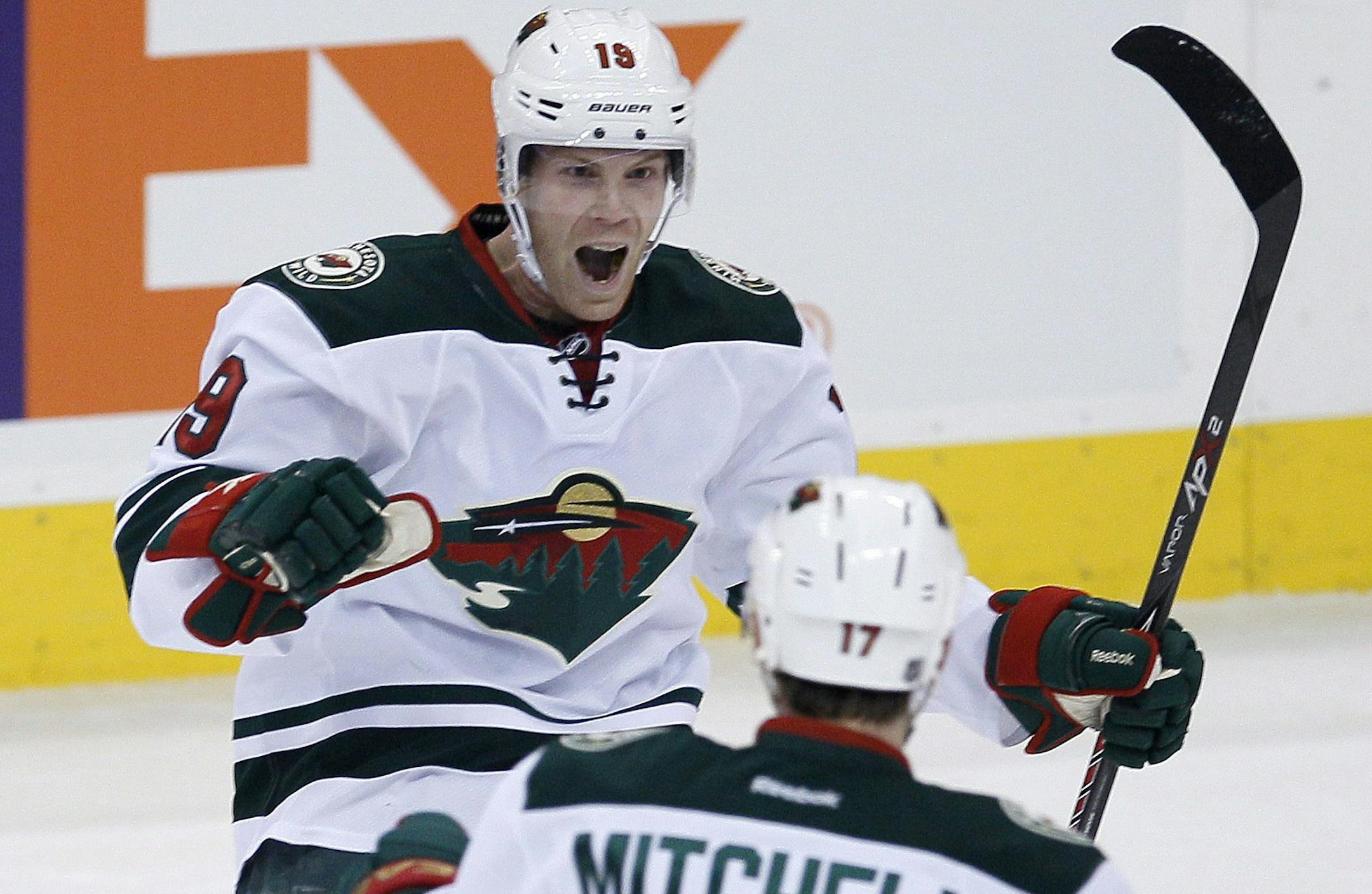 Minnesota Wild's Stephane Veilleux (19) and Torrey Mitchell (17) celebrate Veilleux's goal against the Winnipeg Jets during first-period NHL hockey game action in Winnipeg, Manitoba, Friday, Dec. 27, 2013. (AP Photo/The Canadian Press, John Woods)