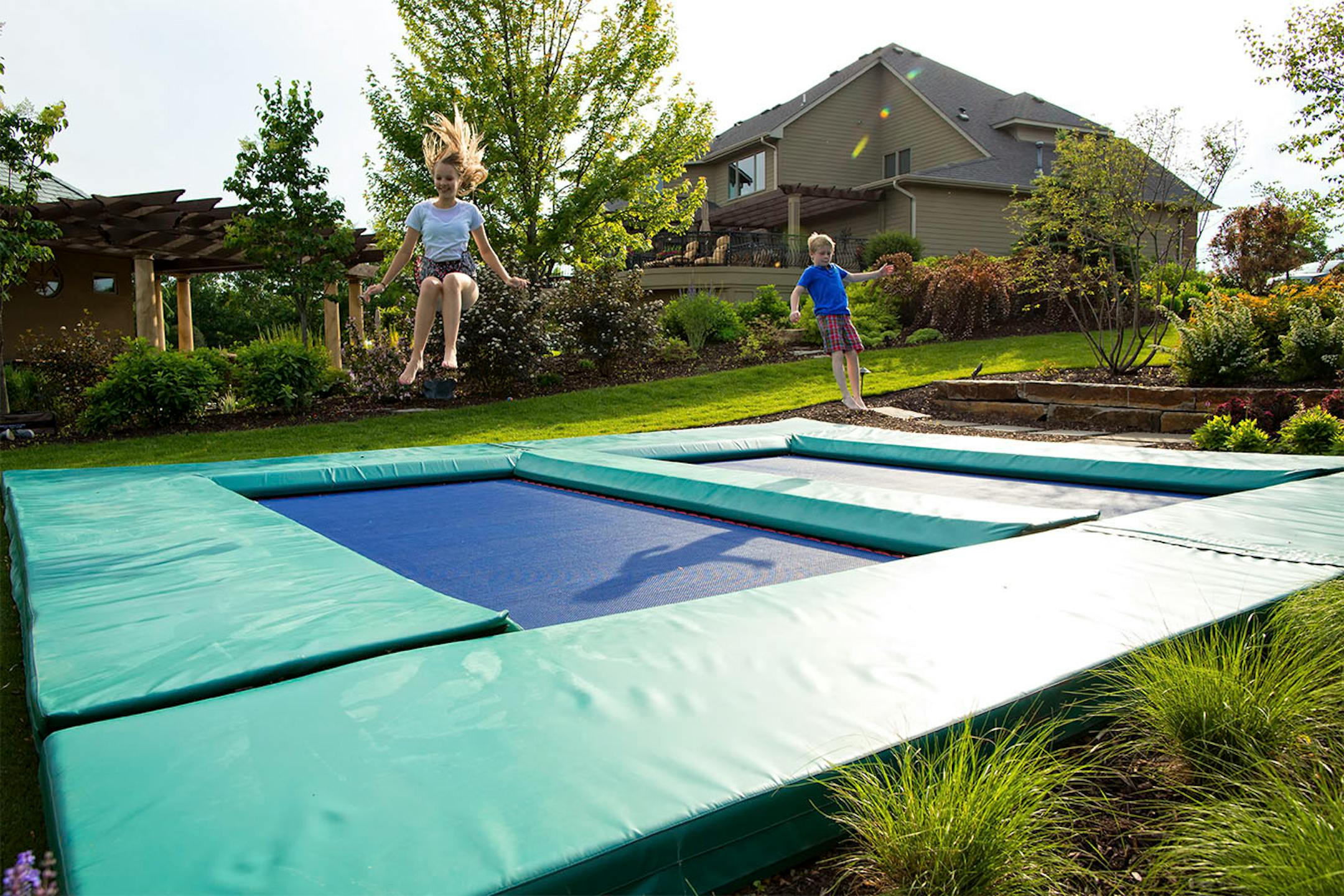 An in-ground trampoline has two jumping surfaces.