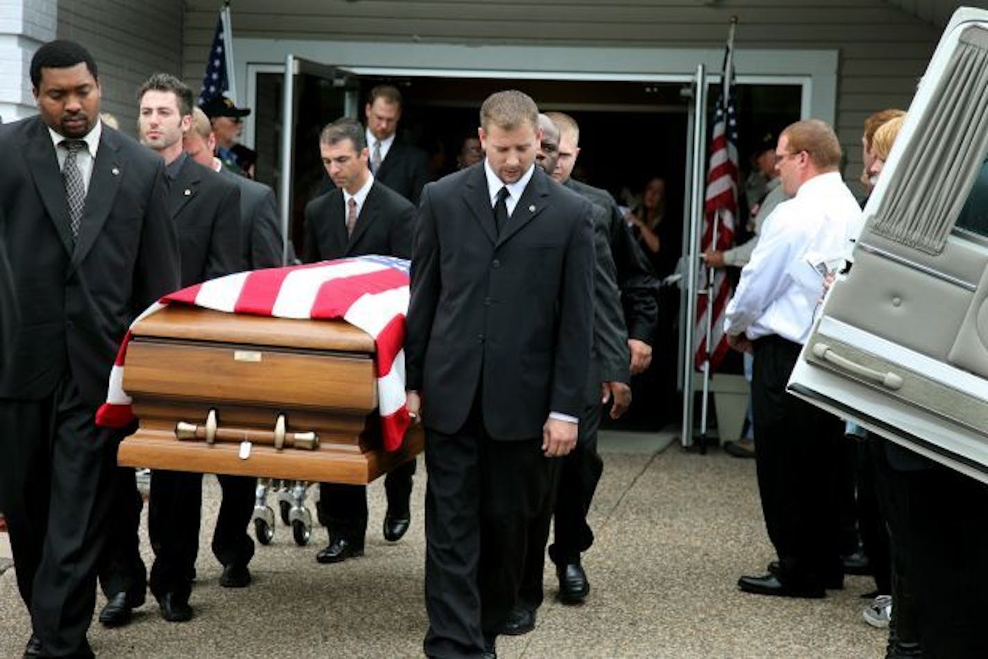 Charles Wilcox III, left, and other pall bearers carried the casket of his brother Spc. Carlos E. Wilcox, IV after his funeral at Light The Way Church.