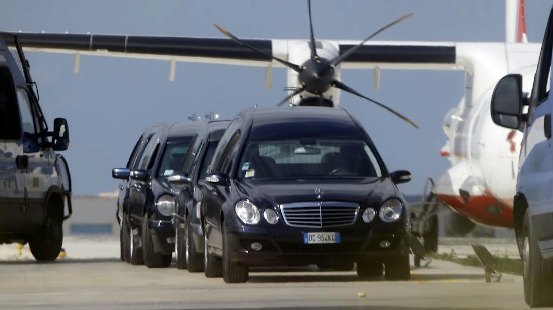 Mortuary vehicles wait outside a hangar where some of the bodies of Thursday's shipwreck are held, at the airport of Lampedusa, Italy, Friday, Oct. 4, 2013. A ship carrying African migrants towards Italy capsized off the Sicilian island of Lampedusa Thursday, spilling hundreds of passengers into the sea, officials said. Authorities resumed Friday their search for bodies in the migrant shipwreck, in which officials say just 155 people survived of the 450 to 500 believed to have been on board.
