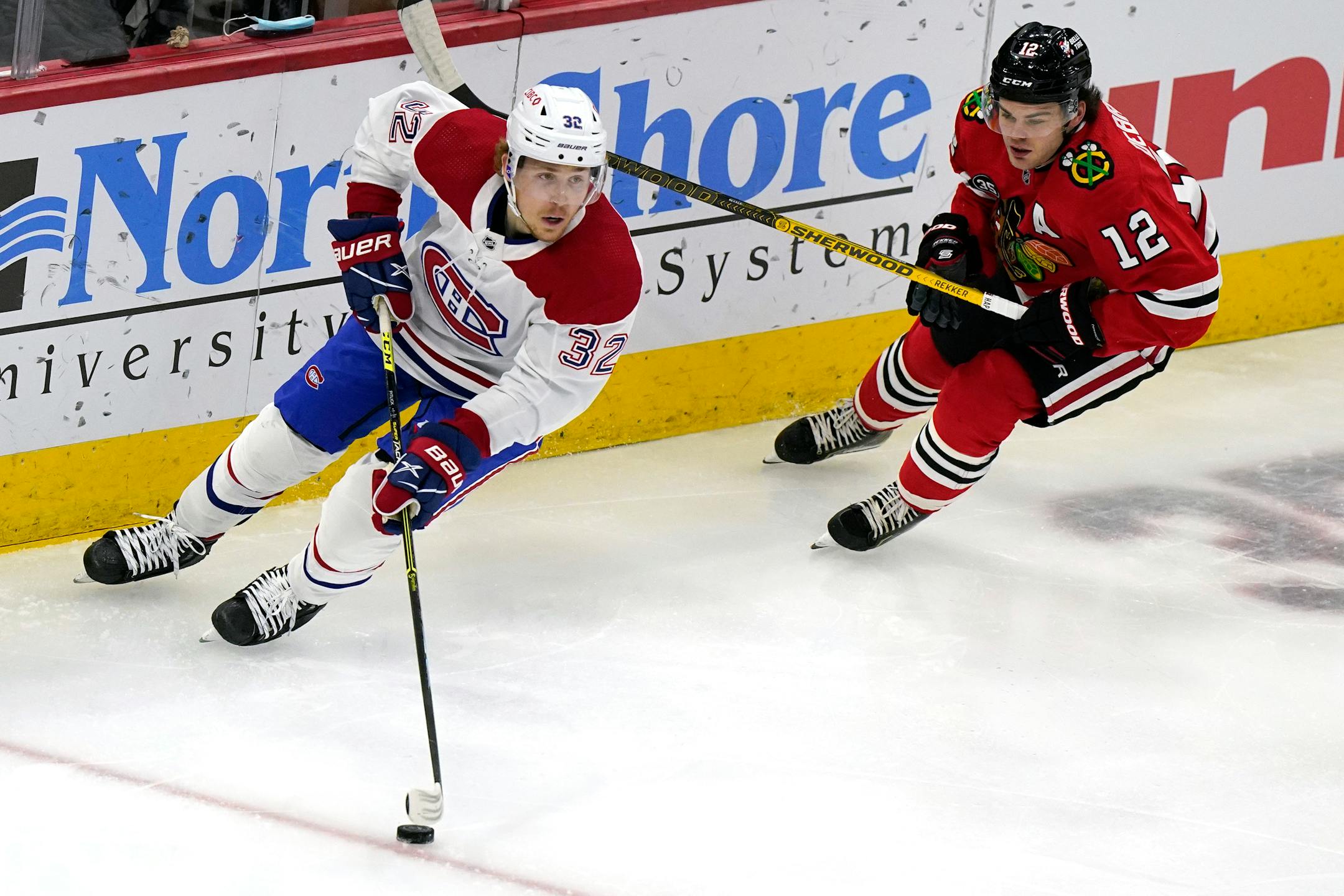 Montreal Canadiens center Rem Pitlick, left, looks to pass against Chicago Blackhawks left wing Alex DeBrincat during the first period of an NHL hockey game in Chicago, Thursday, Jan. 13, 2022. (AP Photo/Nam Y. Huh)