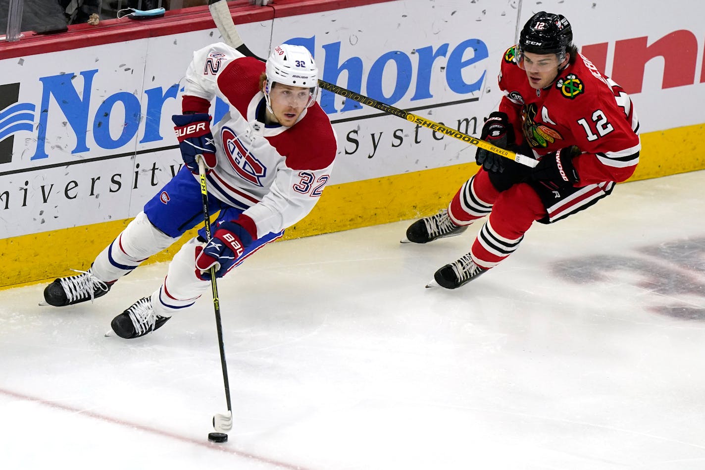 Montreal Canadiens center Rem Pitlick, left, looks to pass against Chicago Blackhawks left wing Alex DeBrincat during the first period of an NHL hockey game in Chicago, Thursday, Jan. 13, 2022. (AP Photo/Nam Y. Huh)