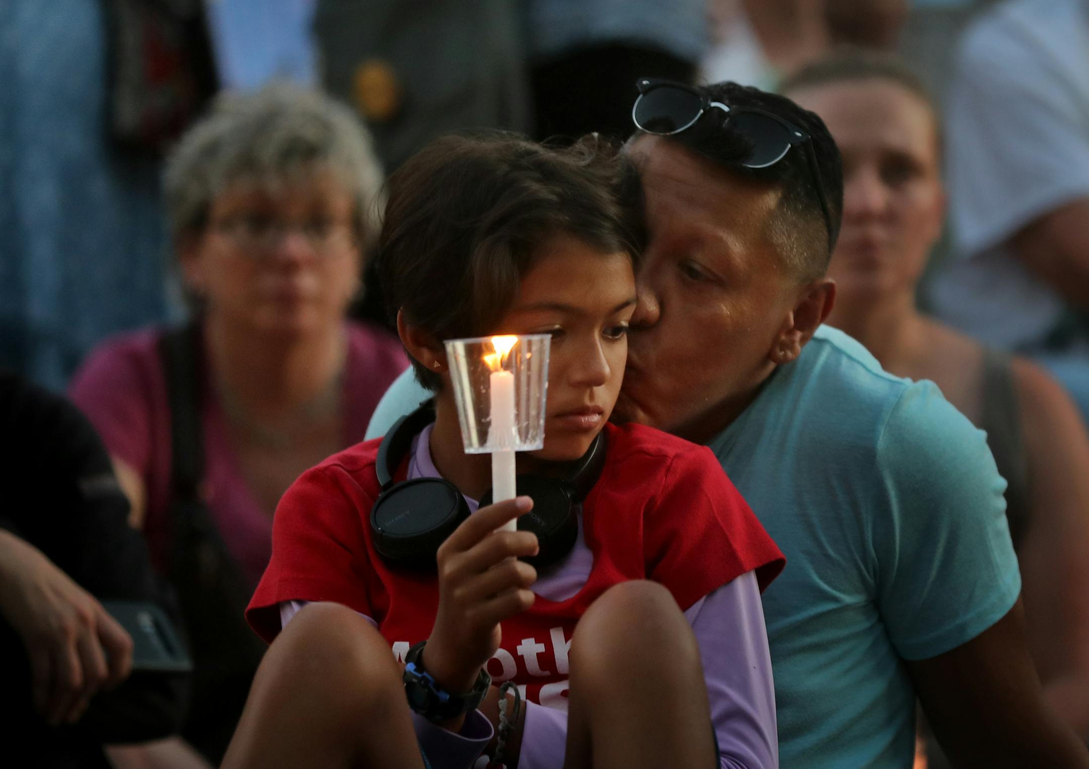 Ruben Vazquez of New Brighton, kissed his daughter Jasmine Vazquez-Matze, 12, in a moment of silence Friday during the Lights for Liberty vigil outside the Whipple Federal Building at Fort Snelling.