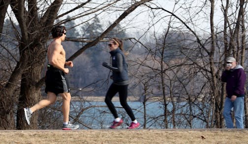 A bare-chested runner enjoyed the last of the spring-like weather while running around Lake Nokomis Wednesday, Feb. 2017, in Minneapolis, MN. Up to a foot of snow is forecast in parts of Minnesota, starting late Thursday.