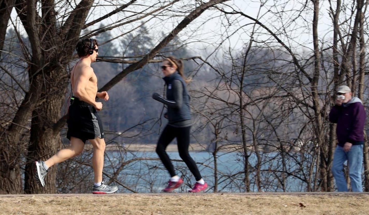 A bare-chested runner enjoyed the last of the spring-like weather while running around Lake Nokomis Wednesday, Feb. 2017, in Minneapolis, MN. Up to a foot of snow is forecast in parts of Minnesota, starting late Thursday.