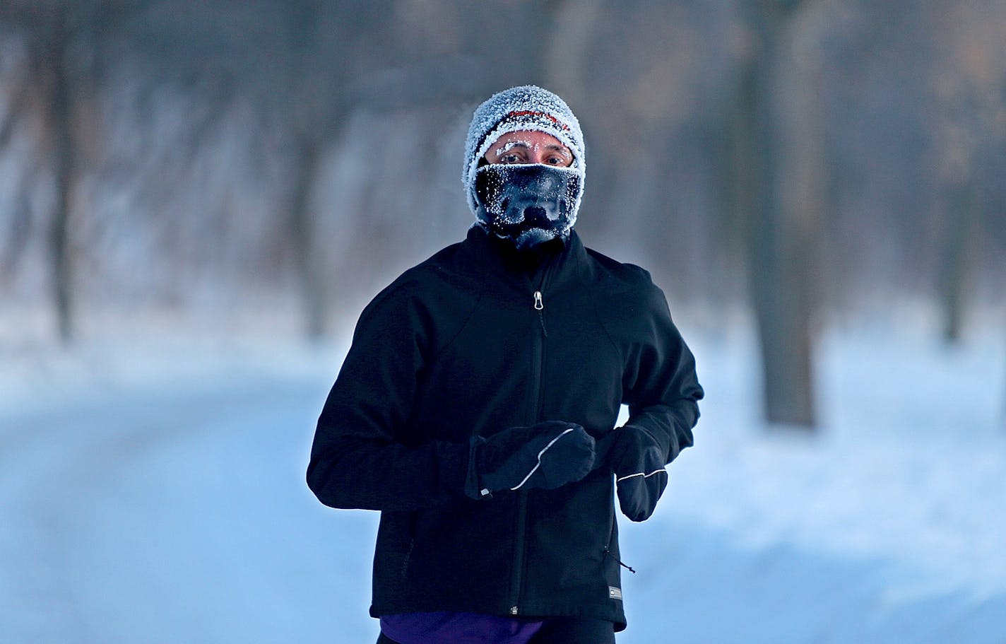 Angela Gustafson braved the -13 degree temperatures for a run around Lake Harriet at sunrise, Tuesday, January 28, 2014 in Minneapolis.