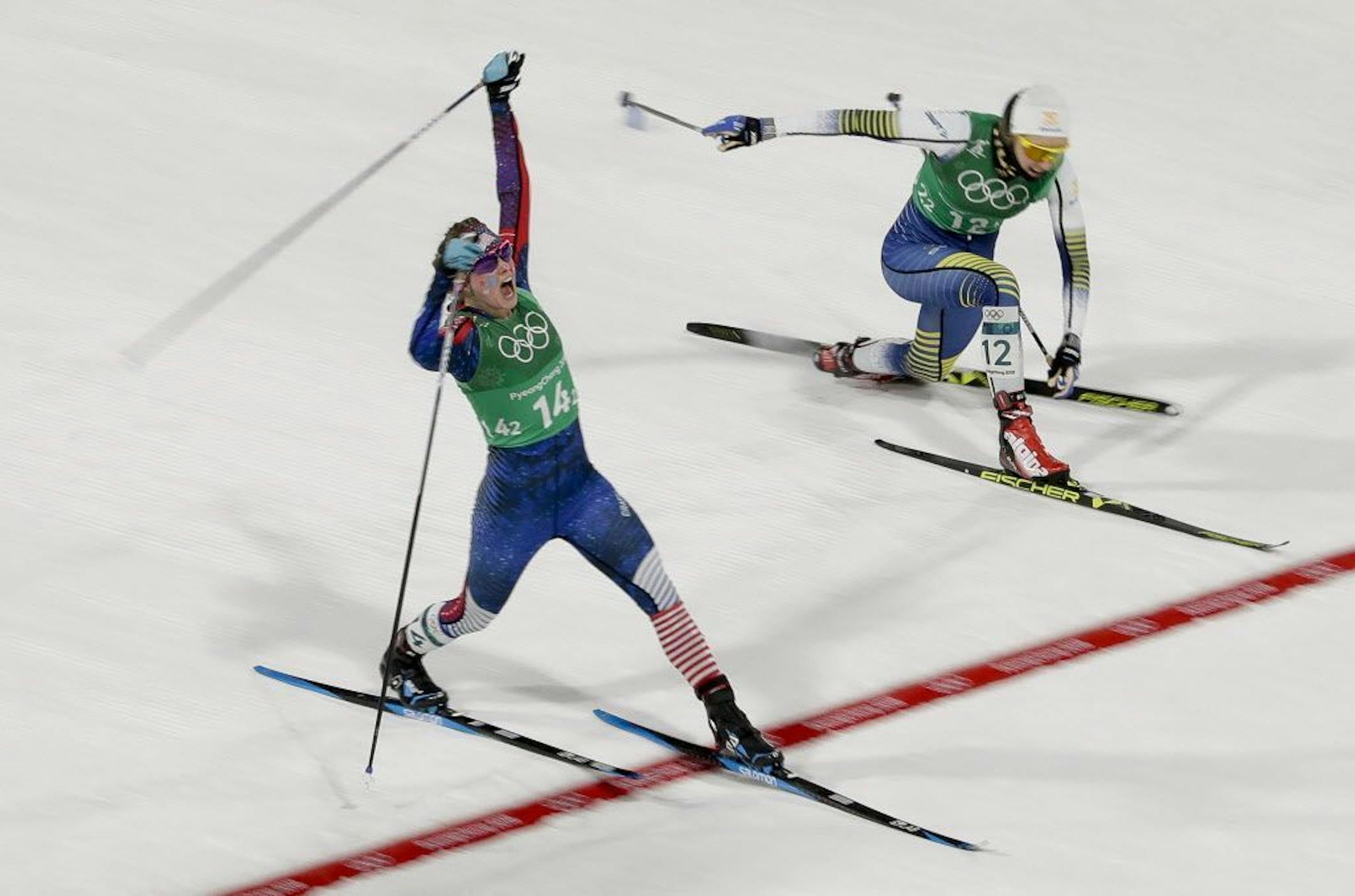 Jessie Diggins, left, of the United States, celebrates after winning the gold medal past Stina Nilsson, of Sweden, in the during women's team sprint freestyle cross-country skiing final at the 2018 Winter Olympics.