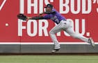 Colorado Rockies left fielder Raimel Tapia reaches in vain for a double by Minnesota Twins' Joe Mauer during the third inning in the second game of a 