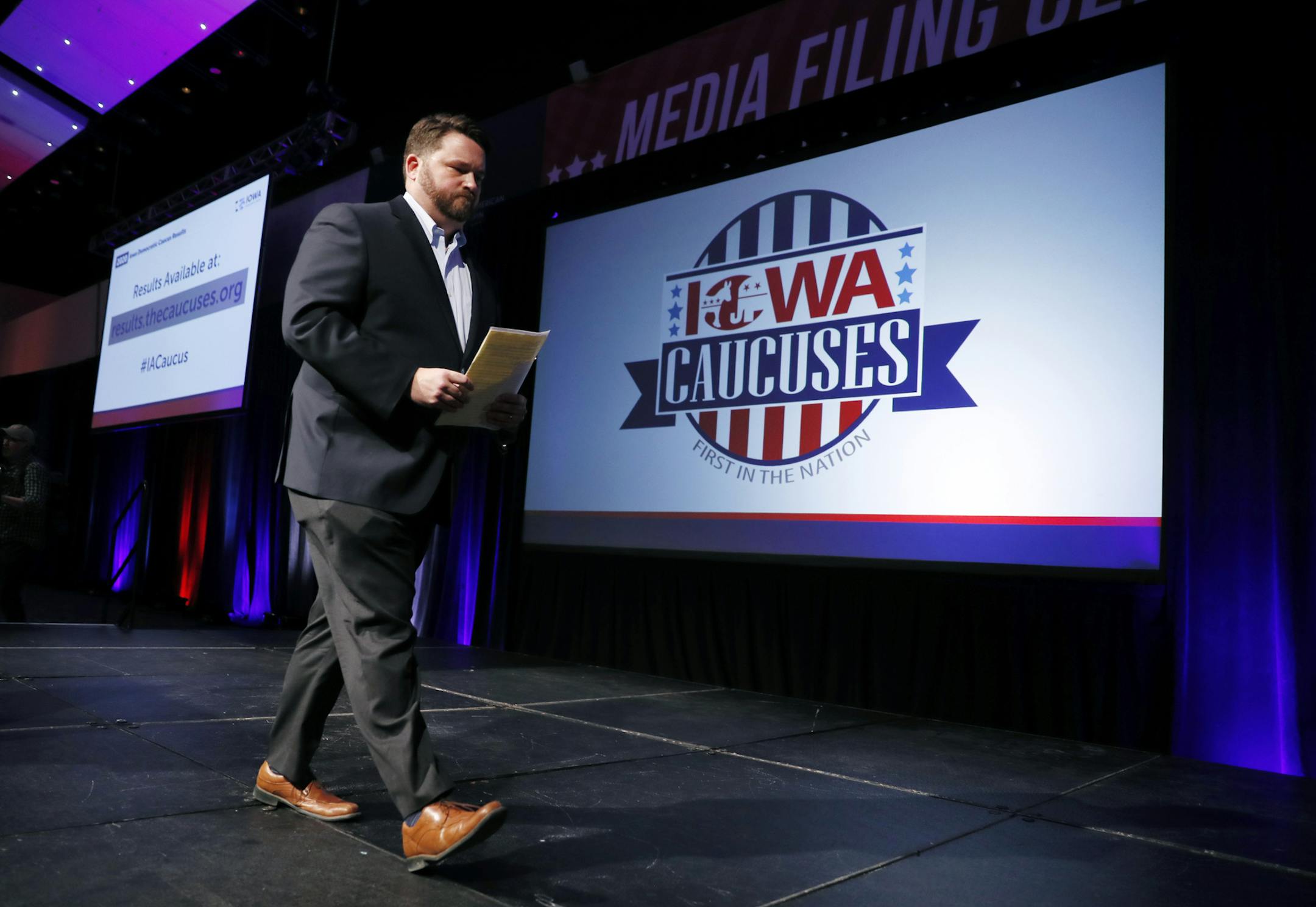 Iowa Democratic Party chairman Troy Price walks off stage after speaking about the delay in Iowa caucus results, Tuesday, Feb. 4, 2020, in Des Moines, Iowa. (AP Photo/Charlie Neibergall)