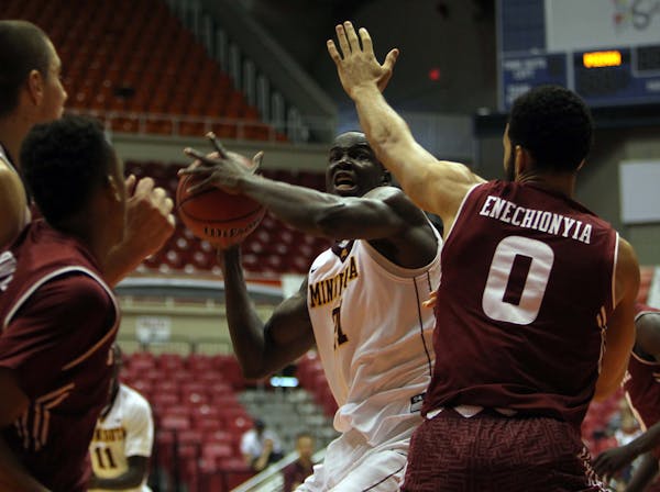 Minnesota center Bakary Konate, center, goes to the basket against Temple forward Obi Enechionyia during the Puerto Rico Tip-Off college basketball to