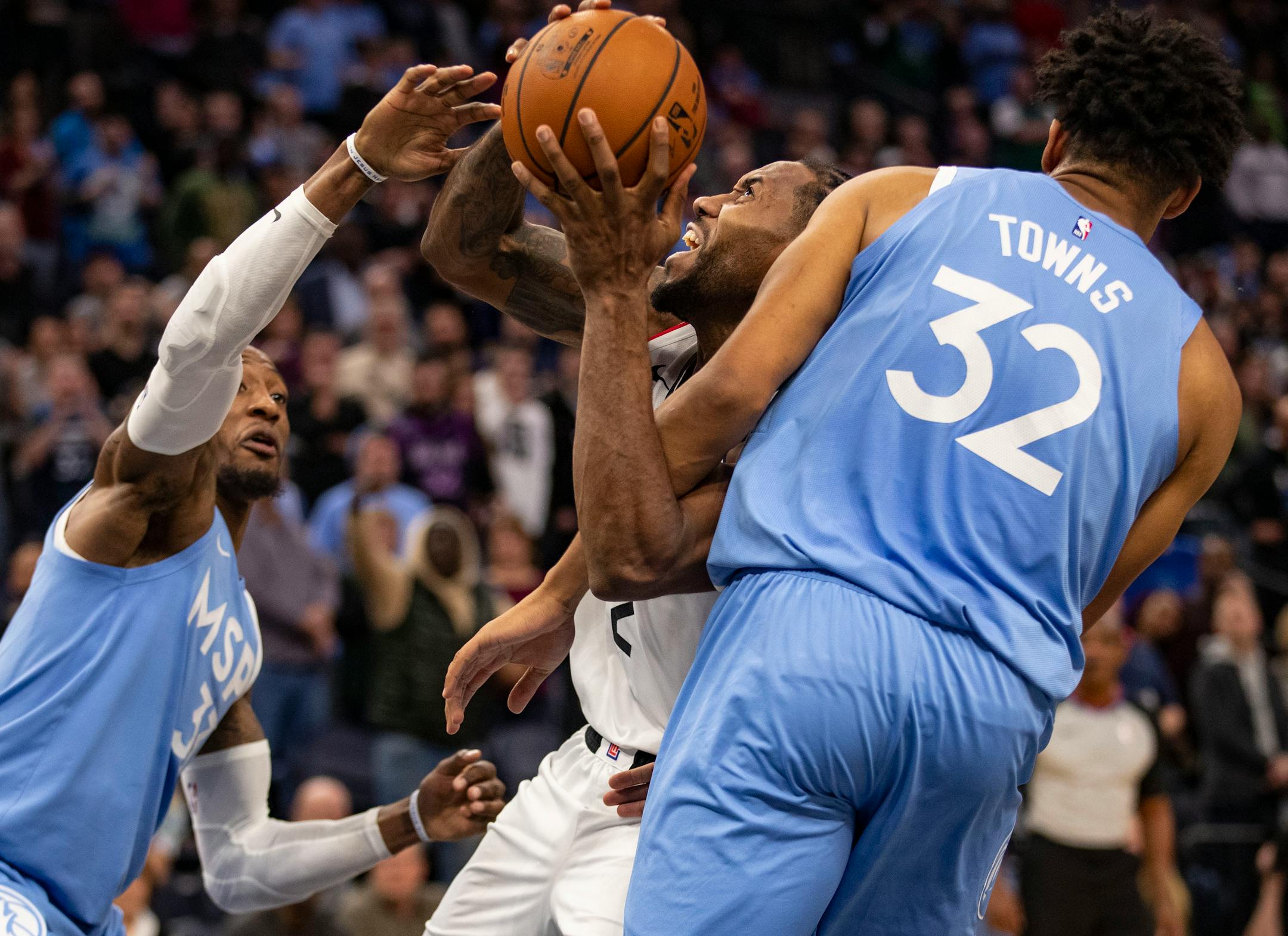 LA Clippers forward Kawhi Leonard (2) tried to muscle through Minnesota Timberwolves center Karl-Anthony Towns (32) for a layup in the fourth quarter.]