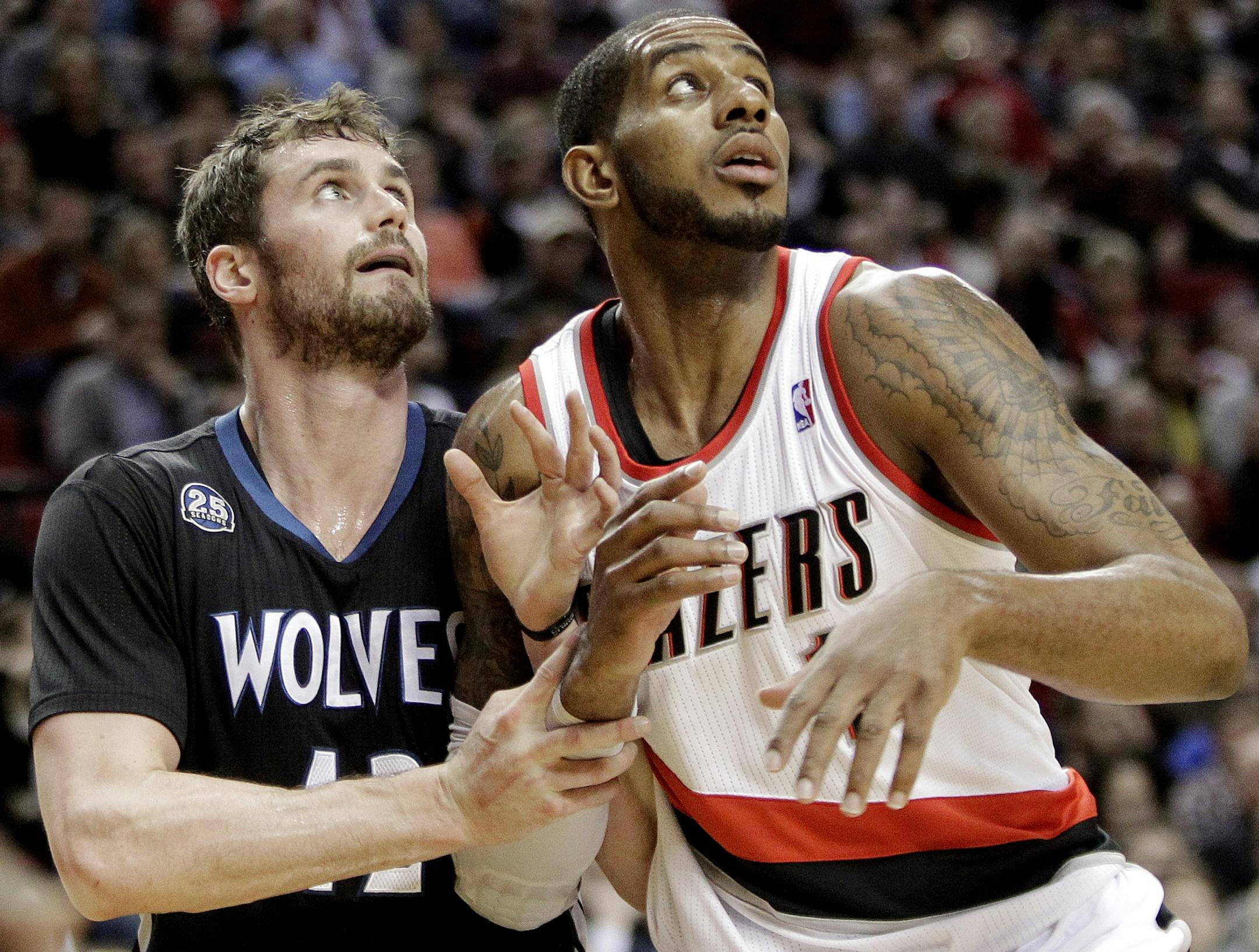 Portland Trail Blazers forward LaMarcus Aldridge, right, battles for position with Minnesota Timberwolves forward Kevin Love during the first half of an NBA basketball game in Portland, Ore., Saturday, Jan. 25, 2014. (AP Photo/Don Ryan)