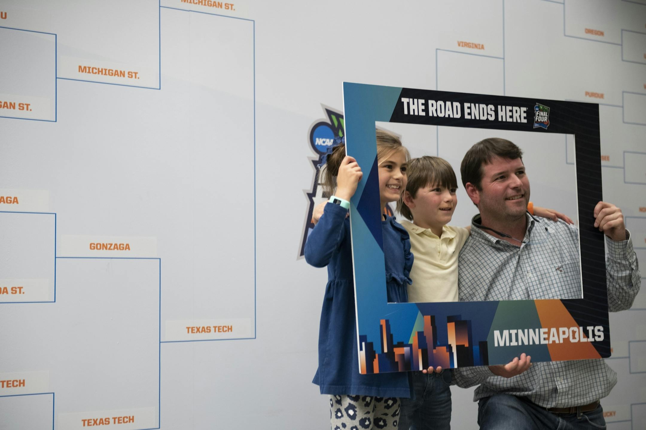 Daniel, Bo and Pierce Samford took a photo in front of the March Madness bracket that was on display at baggage claim. .