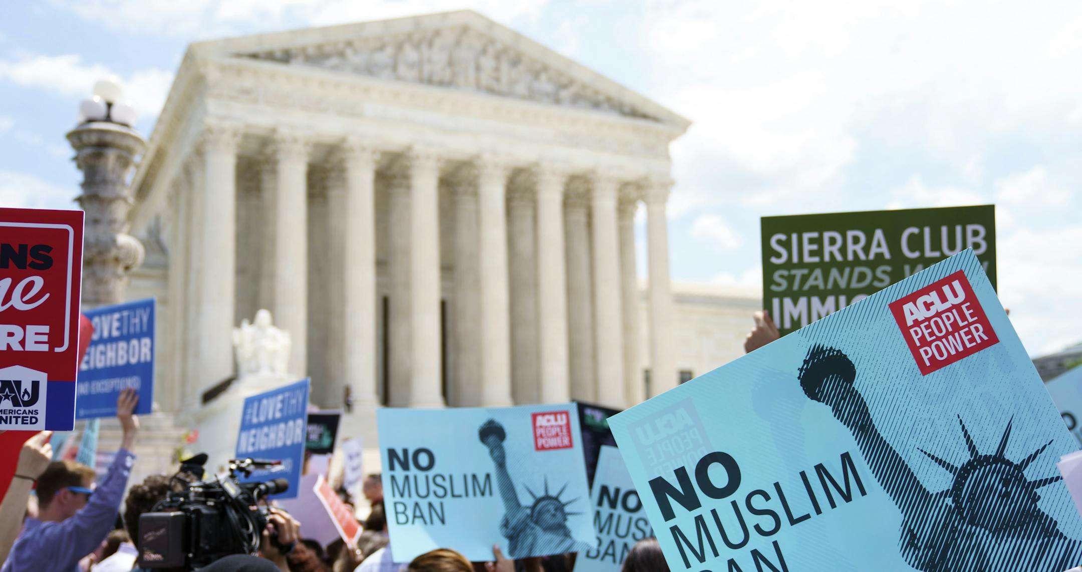 Protesters hold up signs and call out against the Supreme Court ruling upholding President Donald Trump's travel ban outside the the Supreme Court in Washington, Tuesday, June 26, 2018. (AP Photo/Carolyn Kaster)