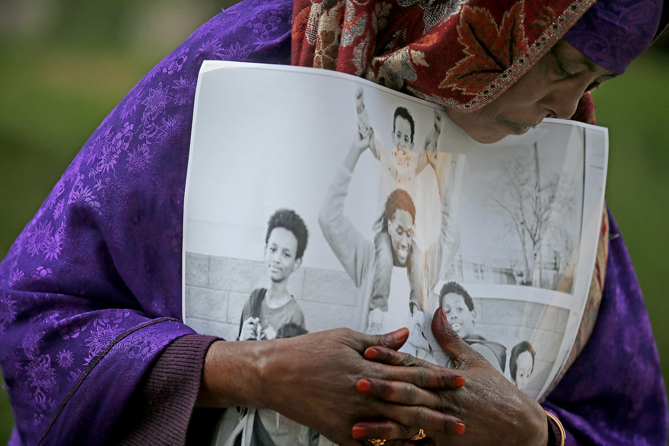 Haqhawo Qaasim holds onto a photo of Guled Ali Omar, who is scheduled to stand trial Monday, while standing in front of the United States Courthouse, Monday, May 9, 2016 in Minneapolis. Omar is one of three defendants who have pleaded not guilty to conspiring to provide material support to the Islamic State group.