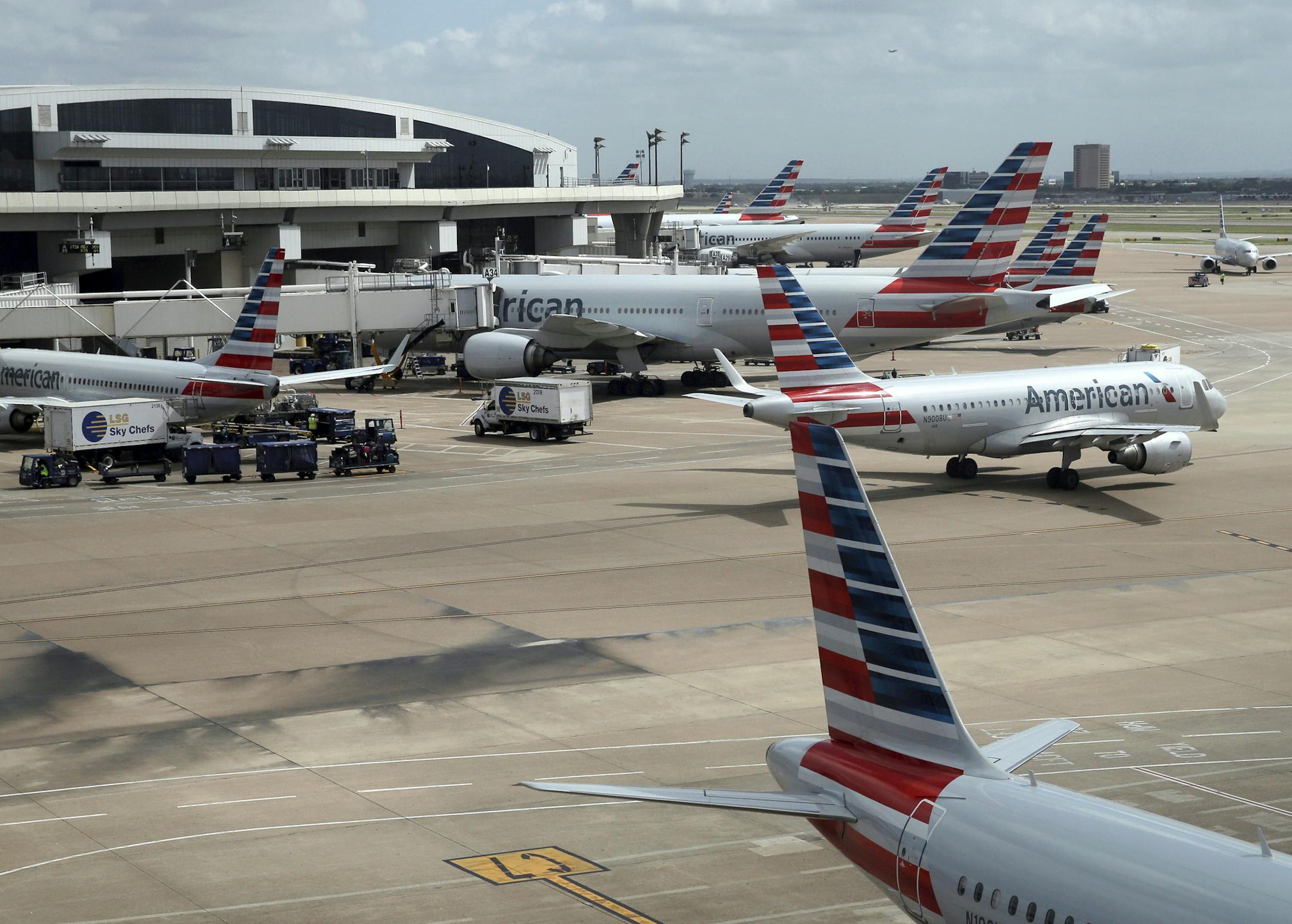 In this June 16, 2018 photo, American Airlines aircrafts are seen at Dallas-Fort Worth International Airport in Grapevine, Texas. American Airlines says it asked the Trump administration not to put migrant children who have been separated from their parents on its flights. In a statement Wednesday, June 20, American said it doesn't know whether any migrant children have been on its flights and doesn't want to profit from the current immigration policy of separating families. (AP Photo/Kiichiro S