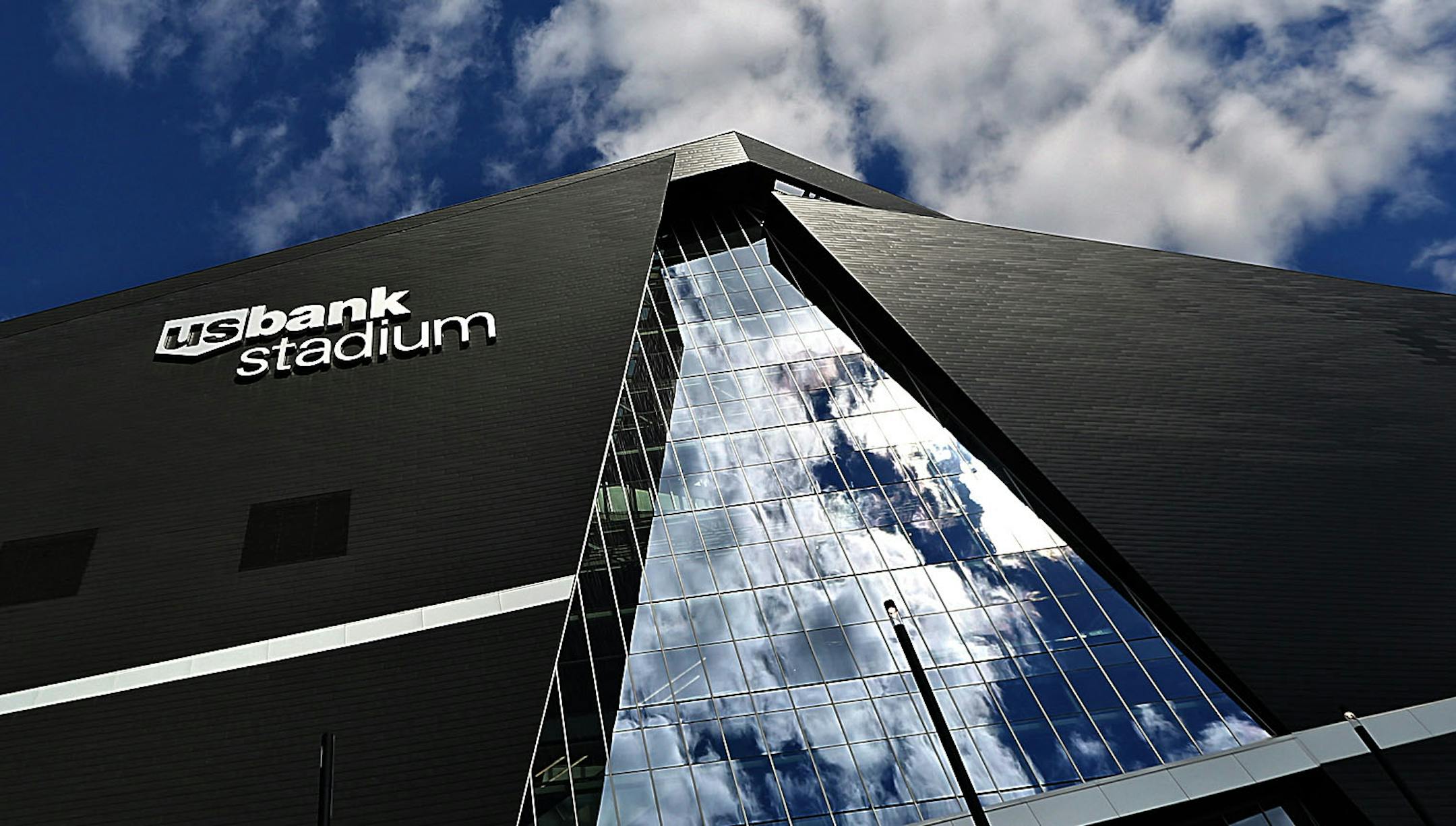 Glass and metal siding outside U.S. Bank Stadium create graphic shapes against the summer sky.