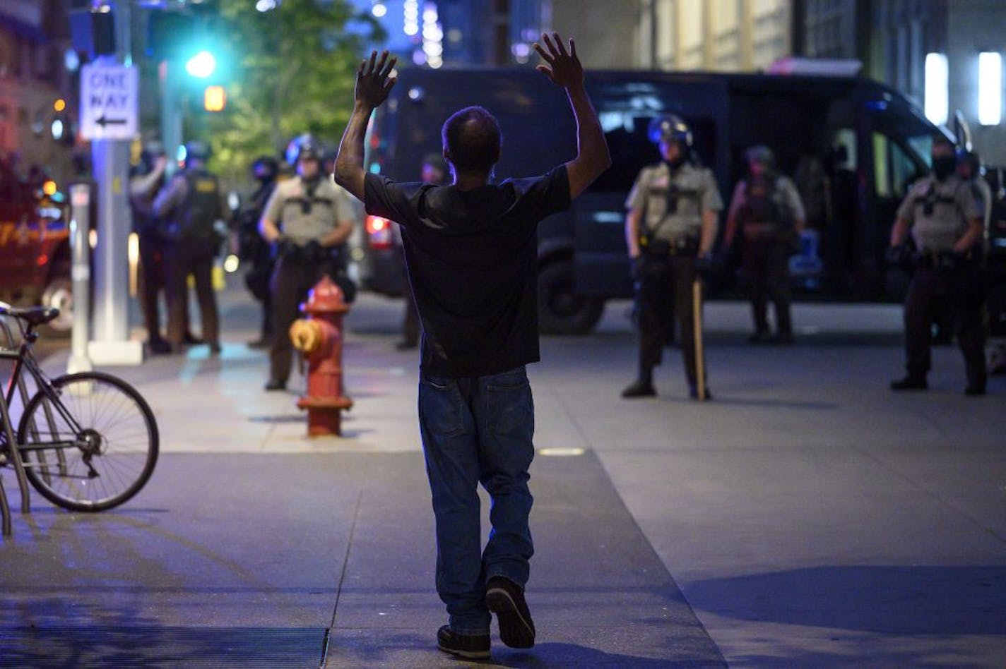 A man lifted his hands in the air as he approached a group of Hennepin County Sherrifs, saying he was on his way home about 20 minutes after curfew went into effect. He was allowed to pass.