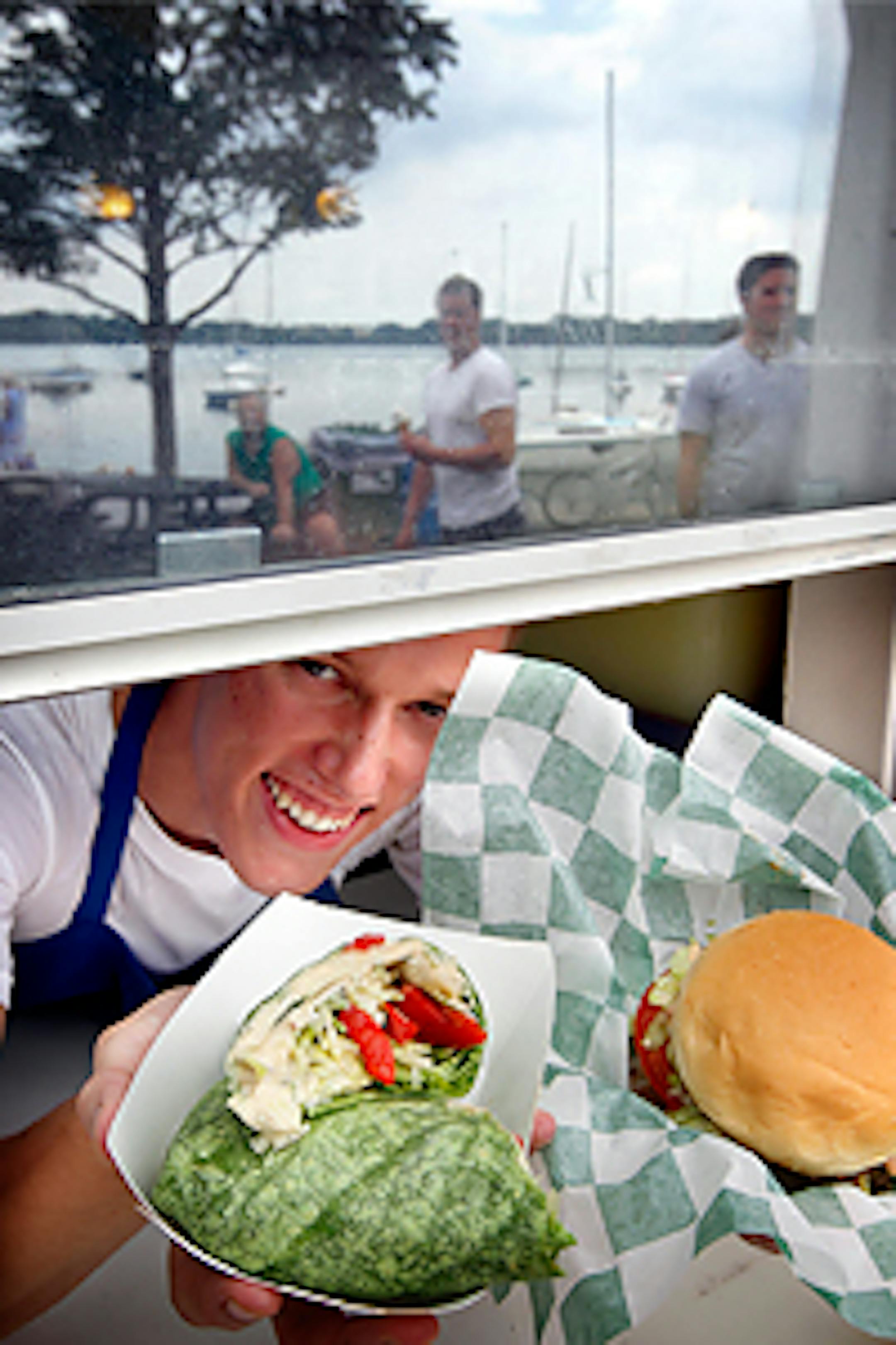 Chuck Noble displays the Humus Wrap and Basic Burger at Bread & Pickle