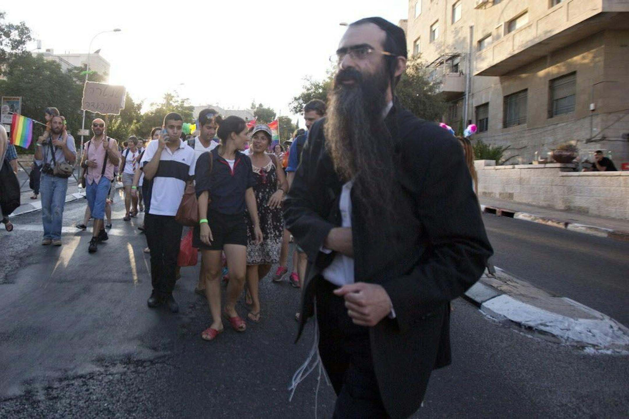 Ultra-Orthodox Jew Yishai Schlissel walks through a Gay Pride parade and is just about to pull a knife from under his coat and start stabbing people in Jerusalem, Thursday, July 30, 2015. Schlissel was recently released from prison after serving a term for stabbing several people at a gay pride parade in 2005, a police spokeswoman said.